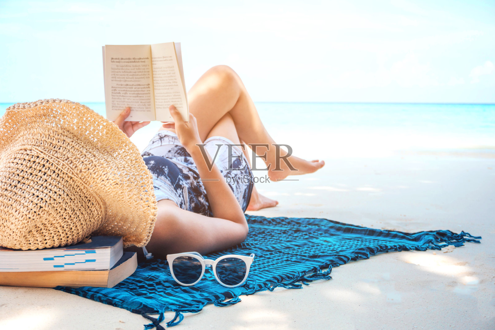 一个女人在暑假的空闲时间在海滩上看书照片摄影图片