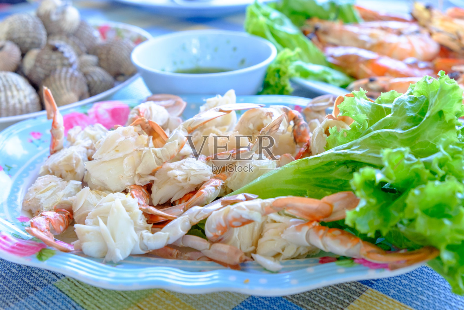 蒸熟的螃蟹剥皮，蟹肉和其他食物一起放在盘子里照片摄影图片