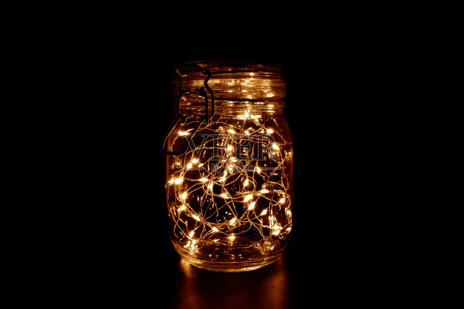 黑暗背景下的玻璃罐中仙女灯照片摄影图片