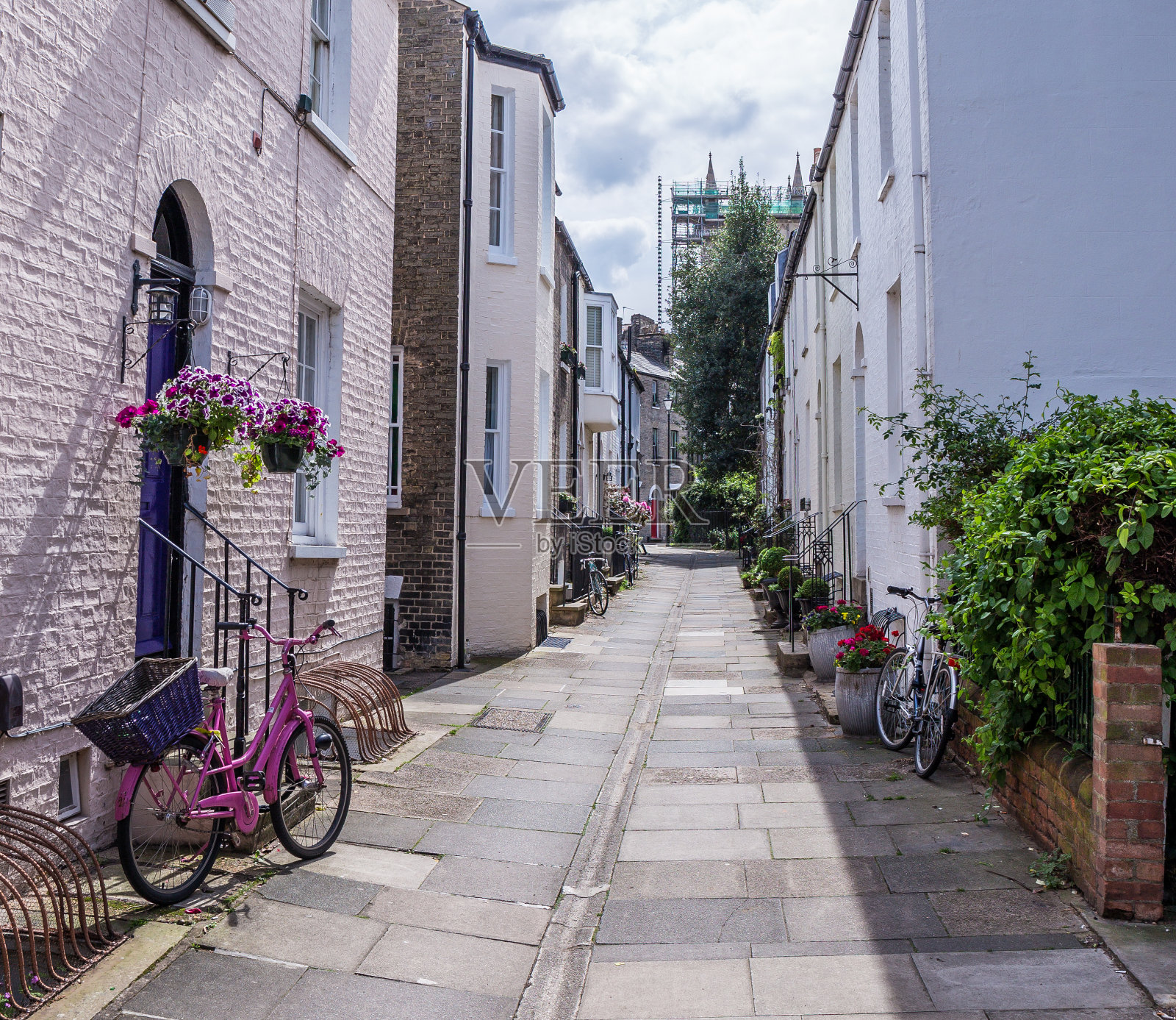 一辆粉红色的自行车在剑桥狭窄的街道上照片摄影图片