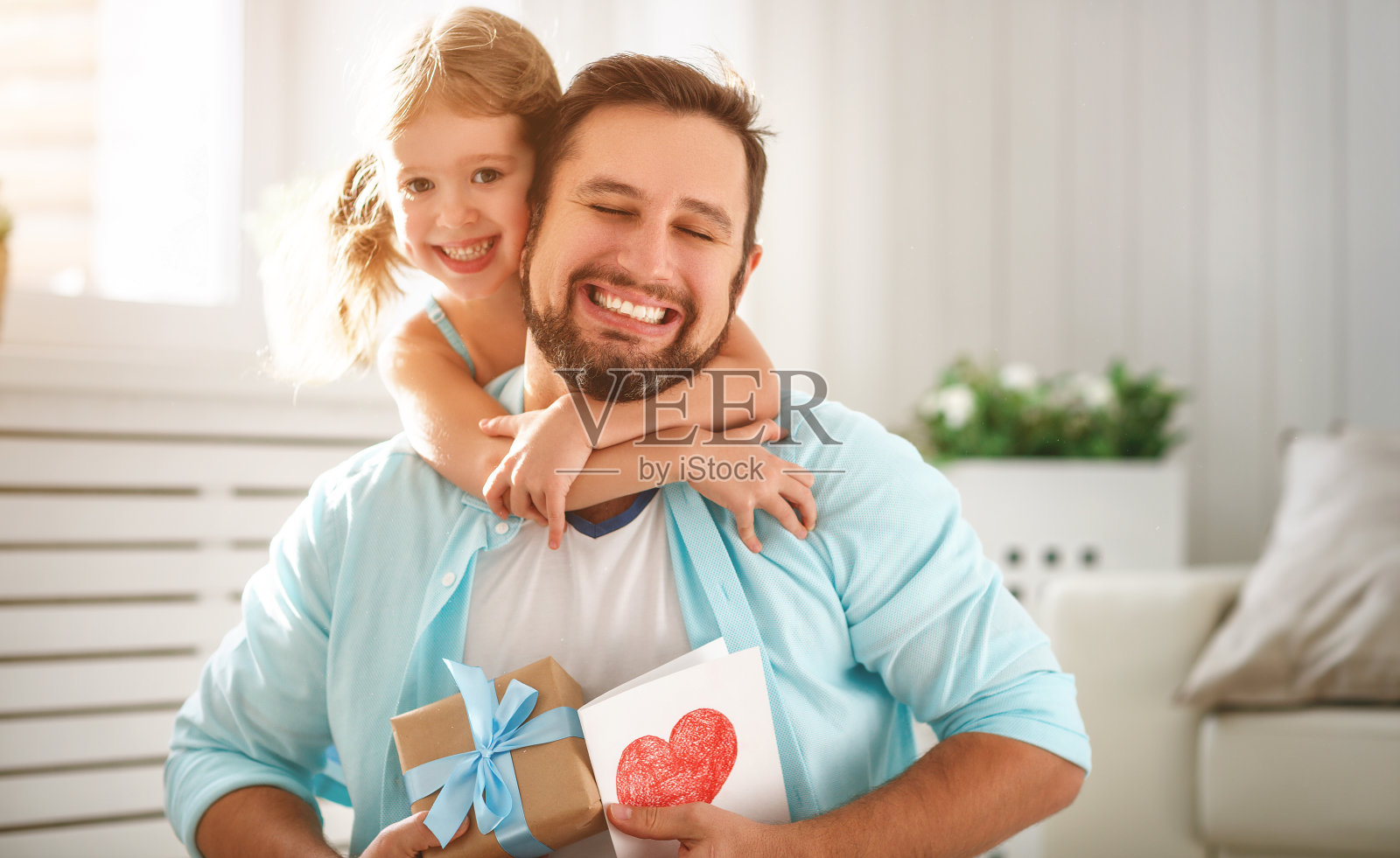 父亲节。幸福的家庭，女儿拥抱爸爸，大笑照片摄影图片