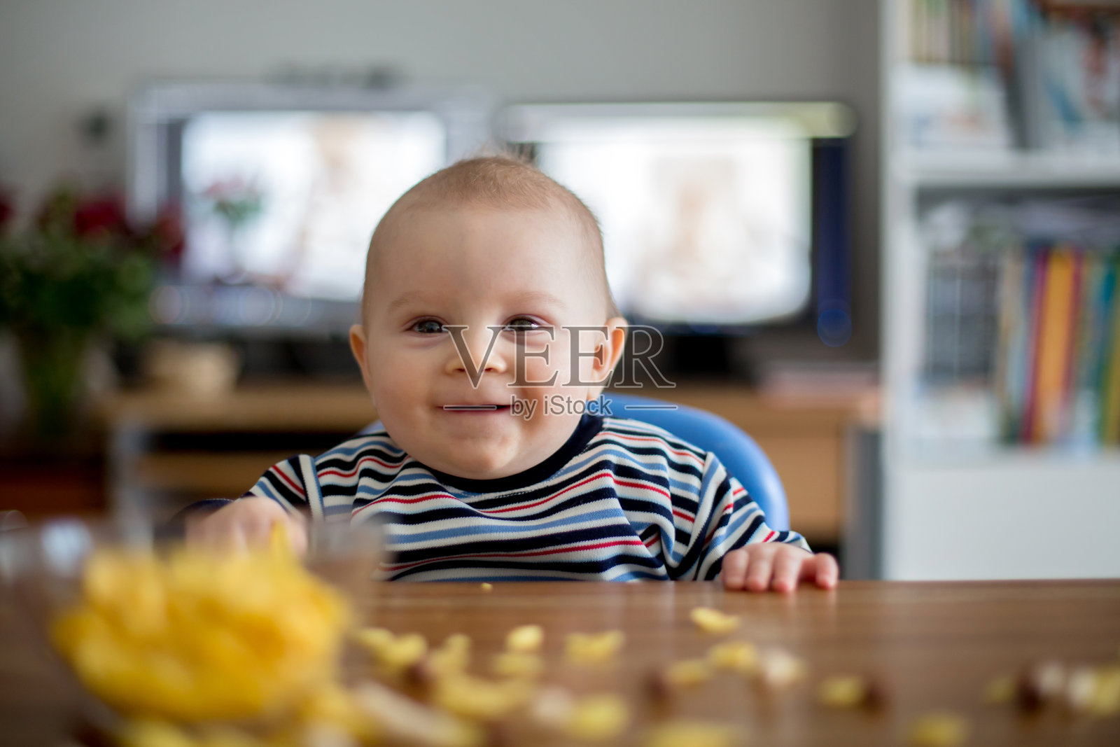 可爱的小男孩吃着玉米片，面带微笑照片摄影图片
