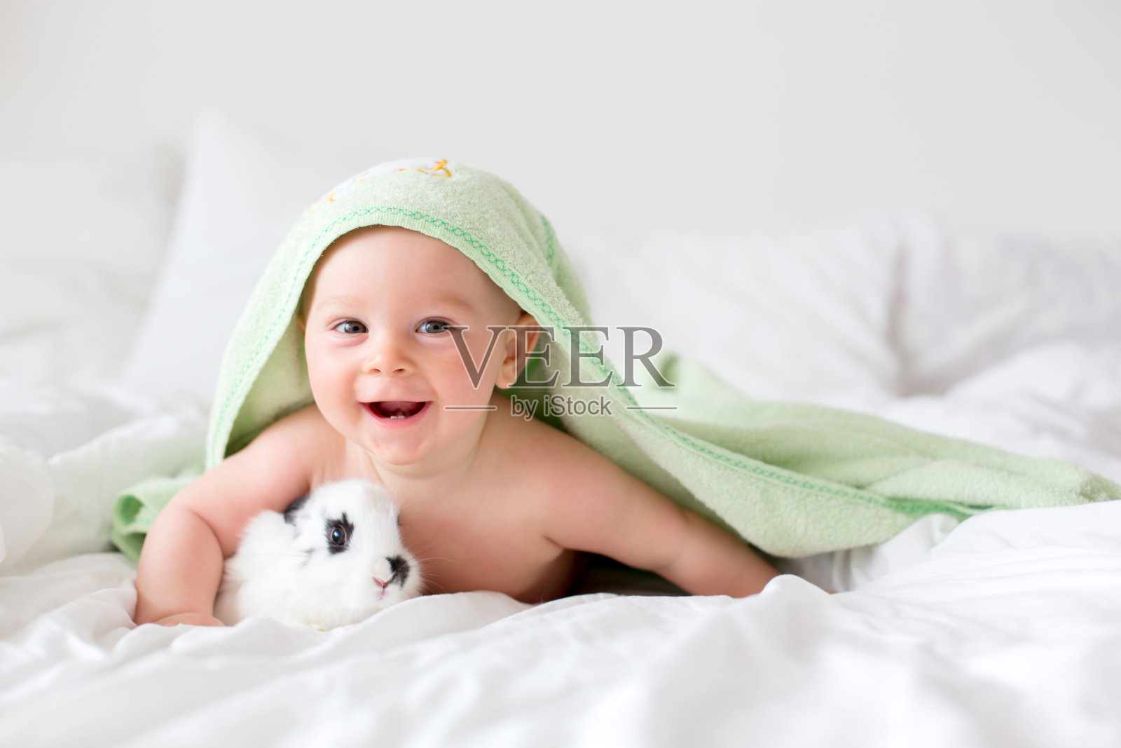 可爱的小男婴和小兔子在床上洗澡后，宝宝洗澡后照片摄影图片