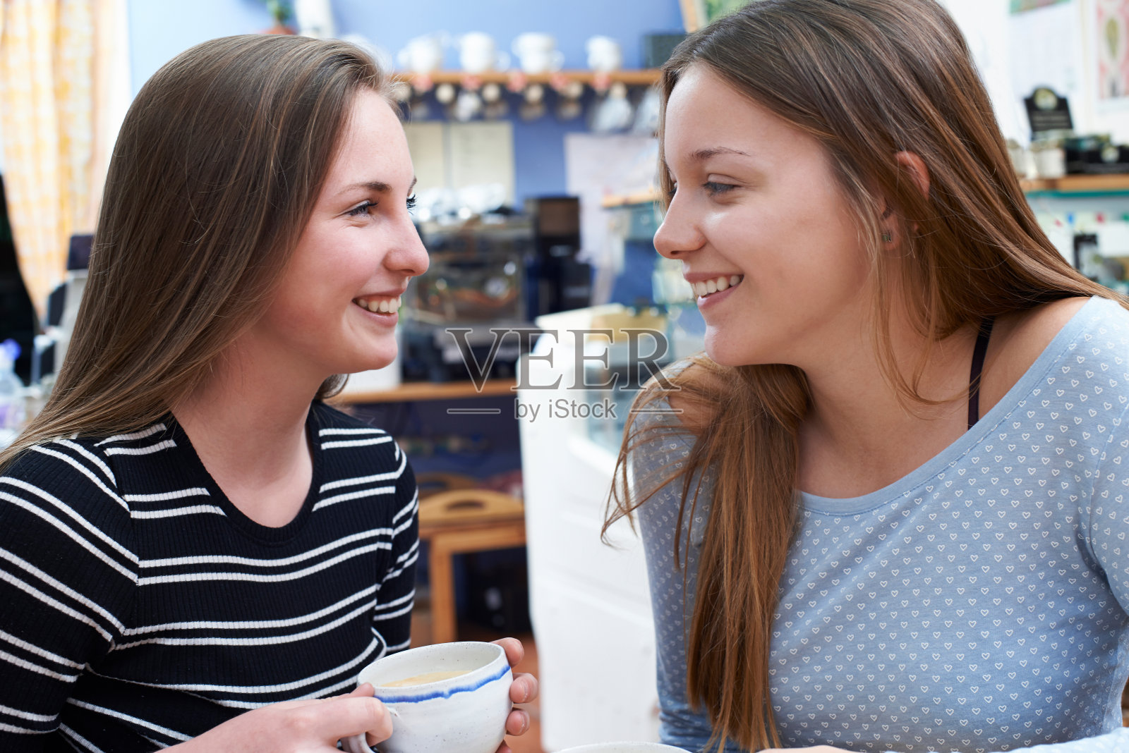 两个十几岁的女性朋友在咖啡馆见面照片摄影图片