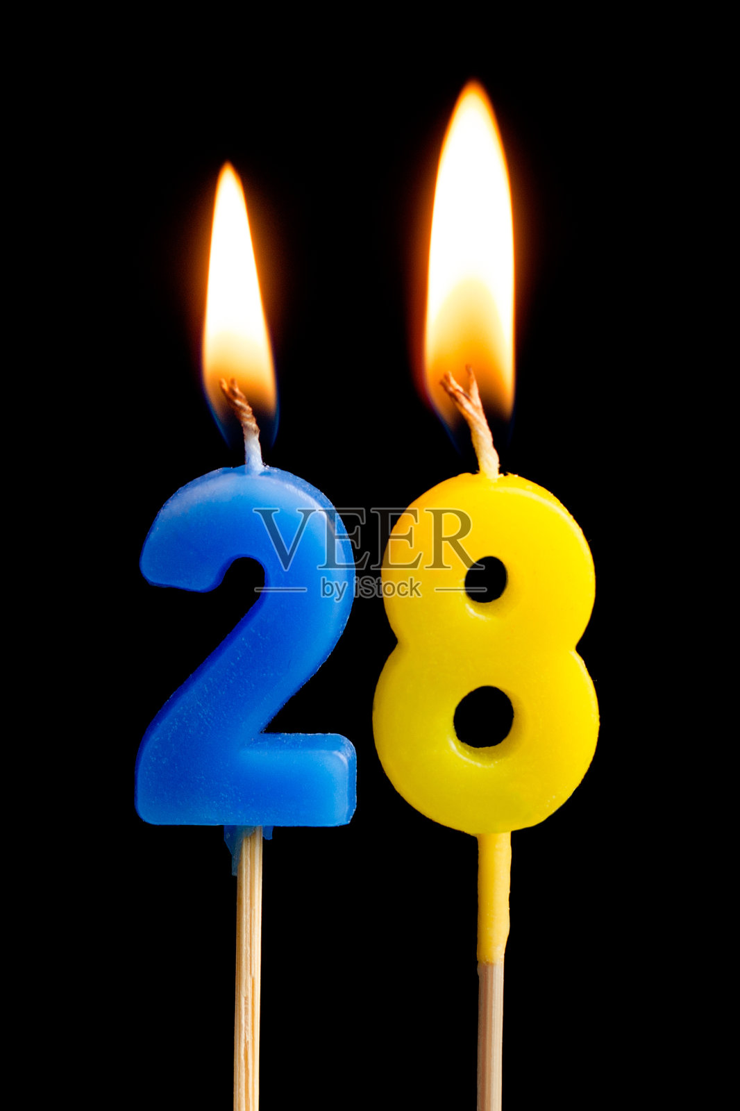 燃烧蜡烛的形式28 28(数字，日期)蛋糕孤立在黑色的背景。庆祝生日、周年纪念、重要日期、节日、餐桌摆设的概念照片摄影图片