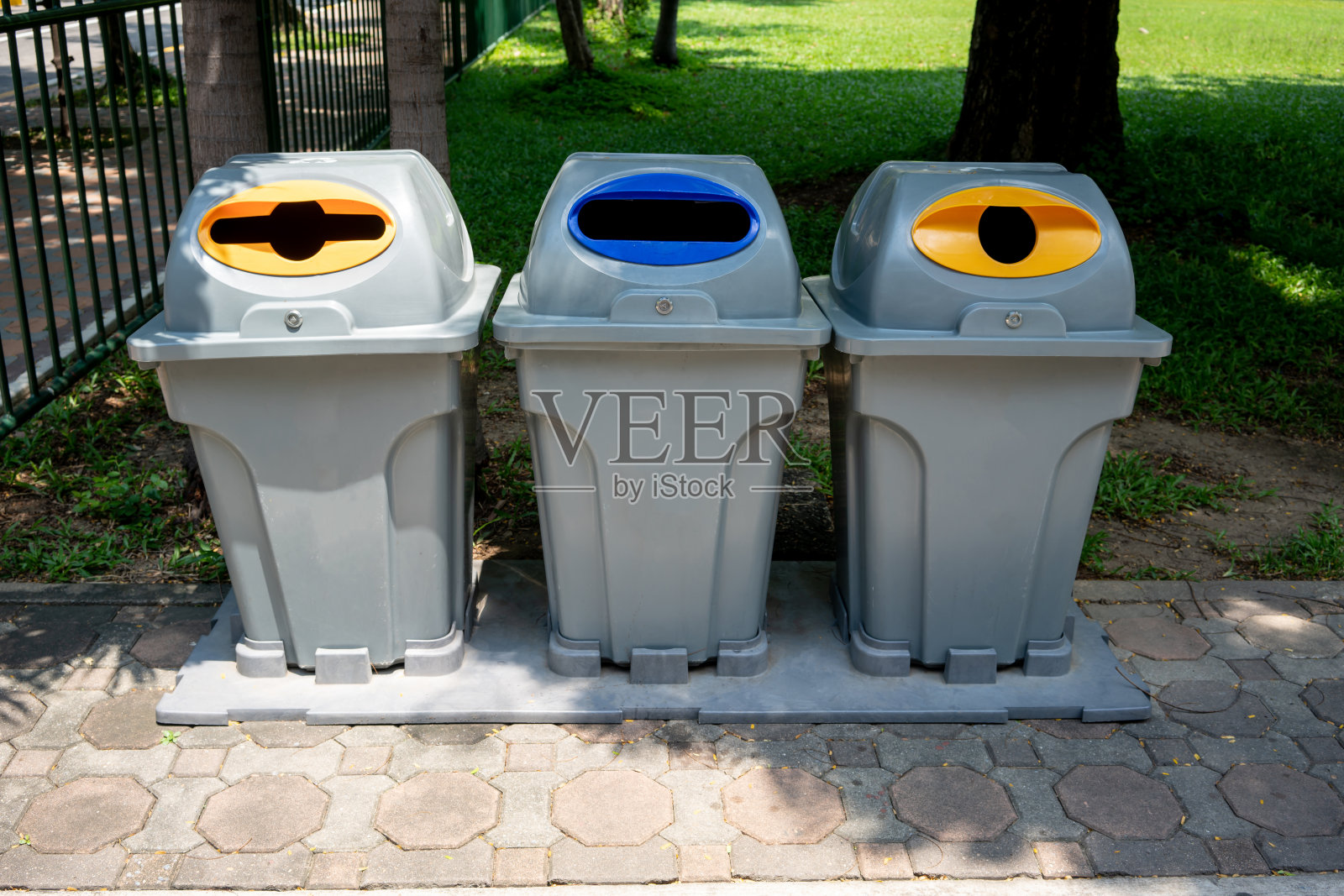 停车场的回收垃圾桶。不同颜色的垃圾桶排成一行进行废物处理。以节约环境观念透视处置观。照片摄影图片