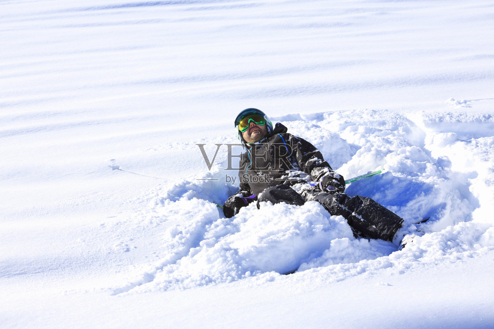 男子滑雪者躺在粉雪中滑雪。在意大利的滑雪胜地Dolomites滑雪。照片摄影图片