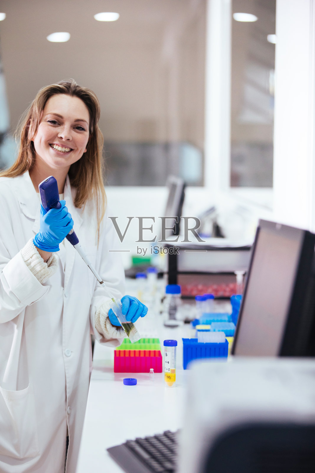 年轻的女科学家在实验室里用移液管工作照片摄影图片