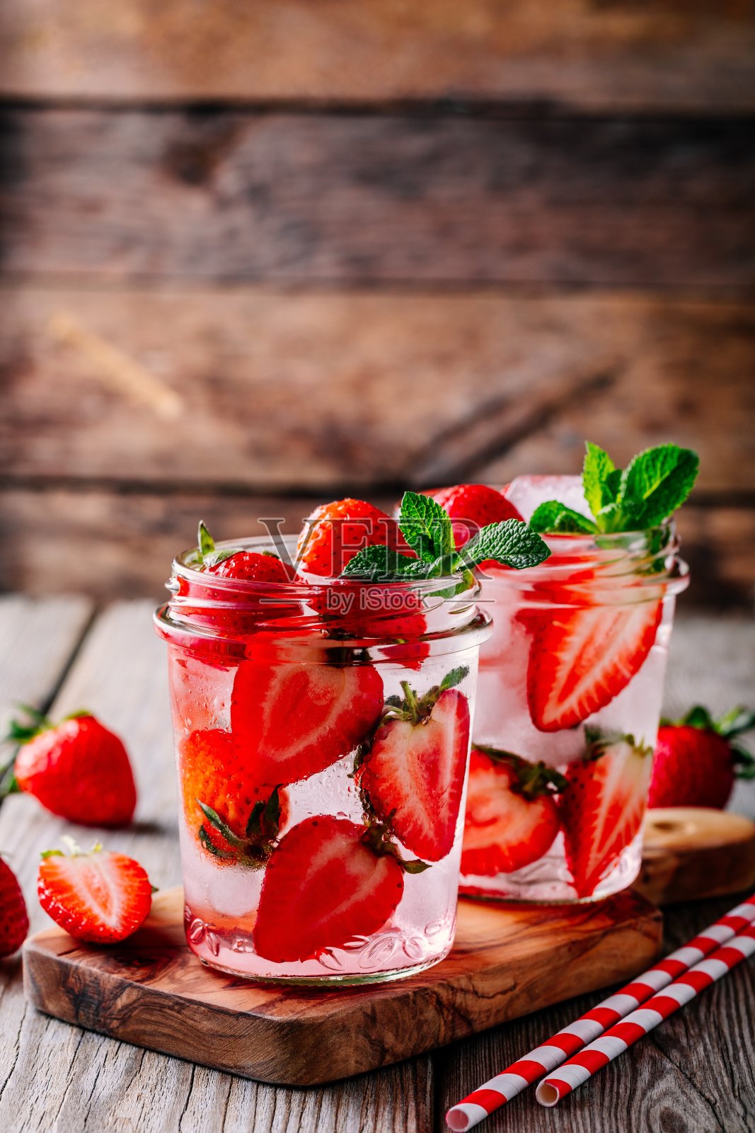 草莓薄荷排毒水。冰镇的夏季鸡尾酒或柠檬水在玻璃玻璃瓶照片摄影图片