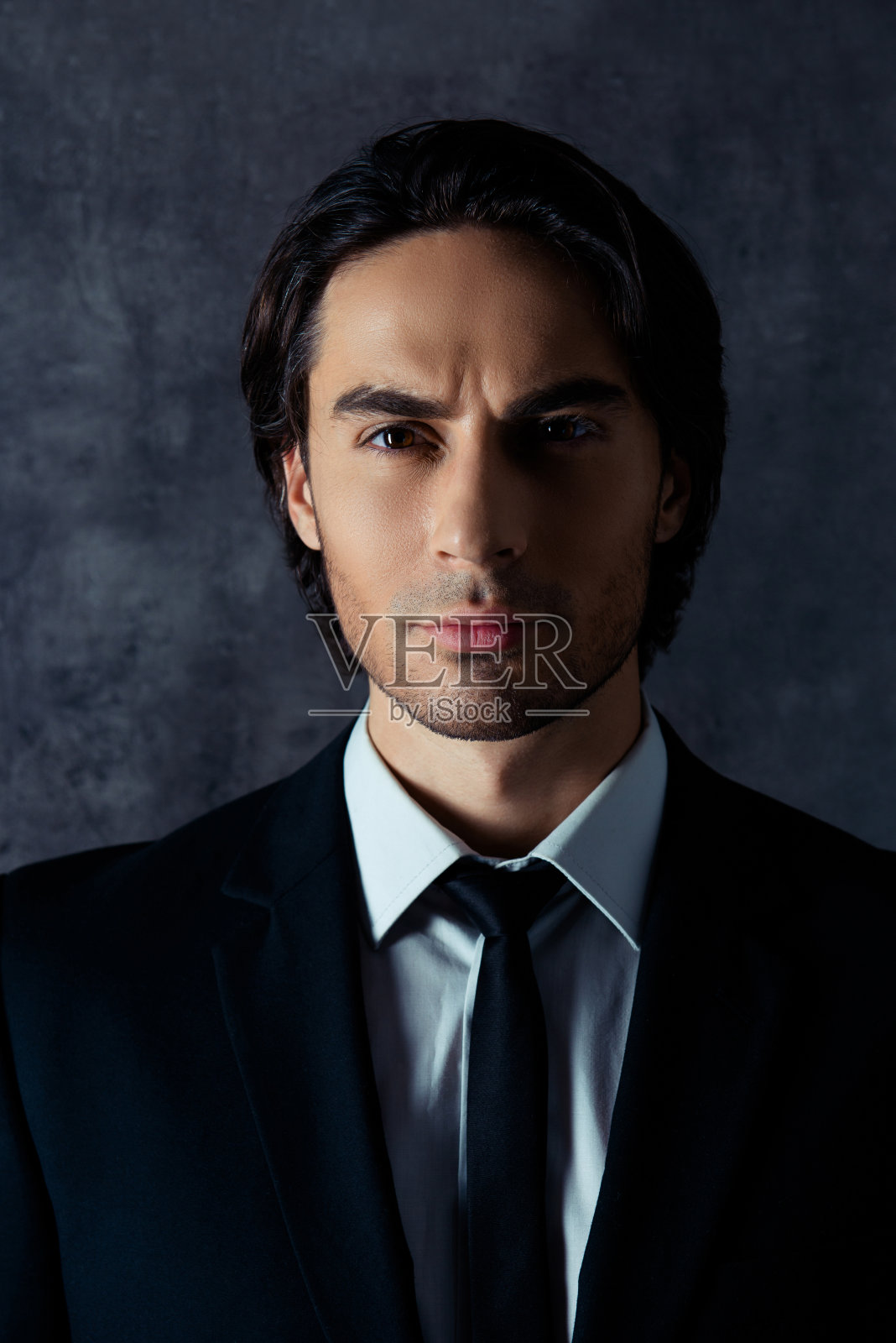 帅气的西班牙男子肖像在灰色的背景照片摄影图片