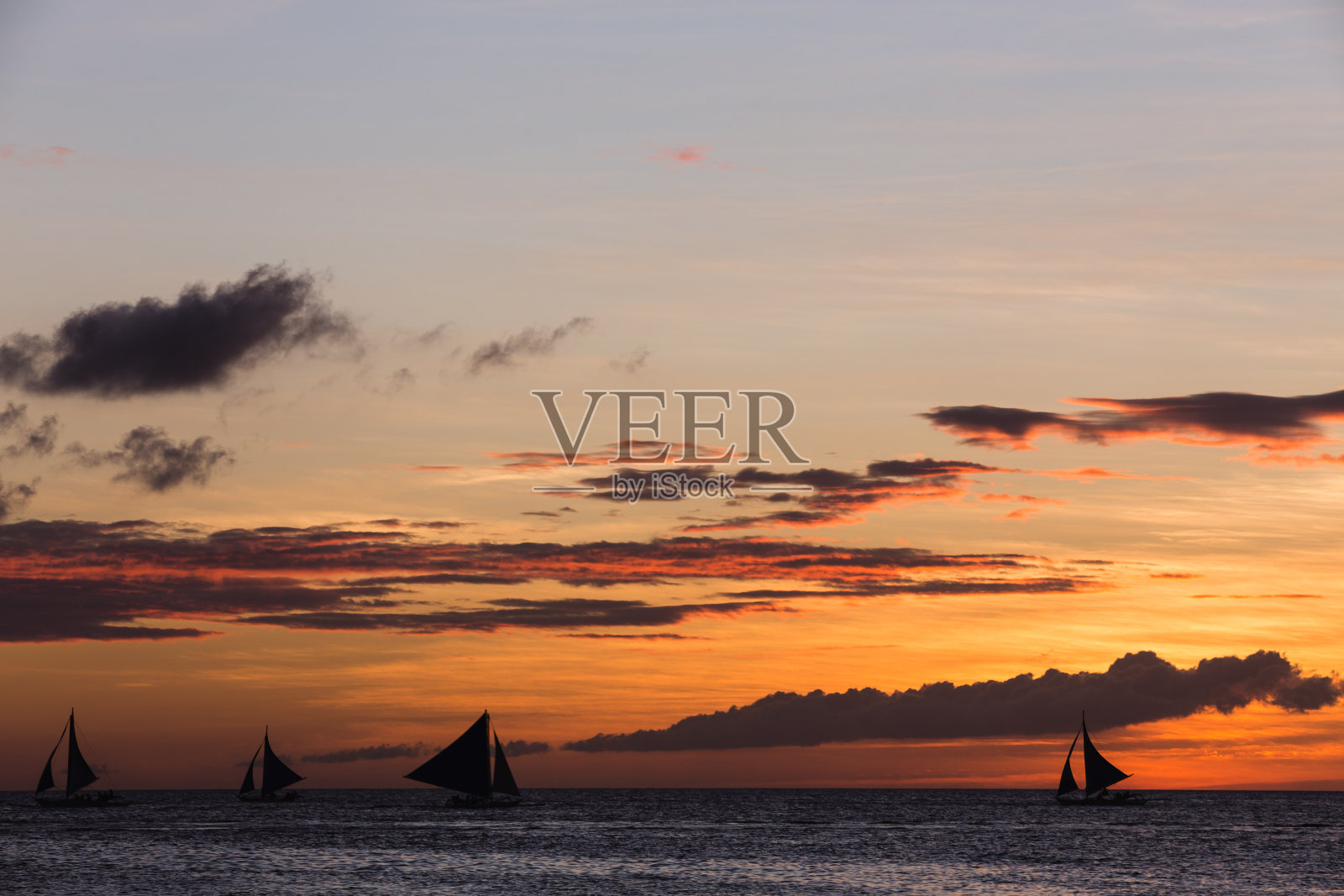 日落时地平线上的支腿帆船照片摄影图片