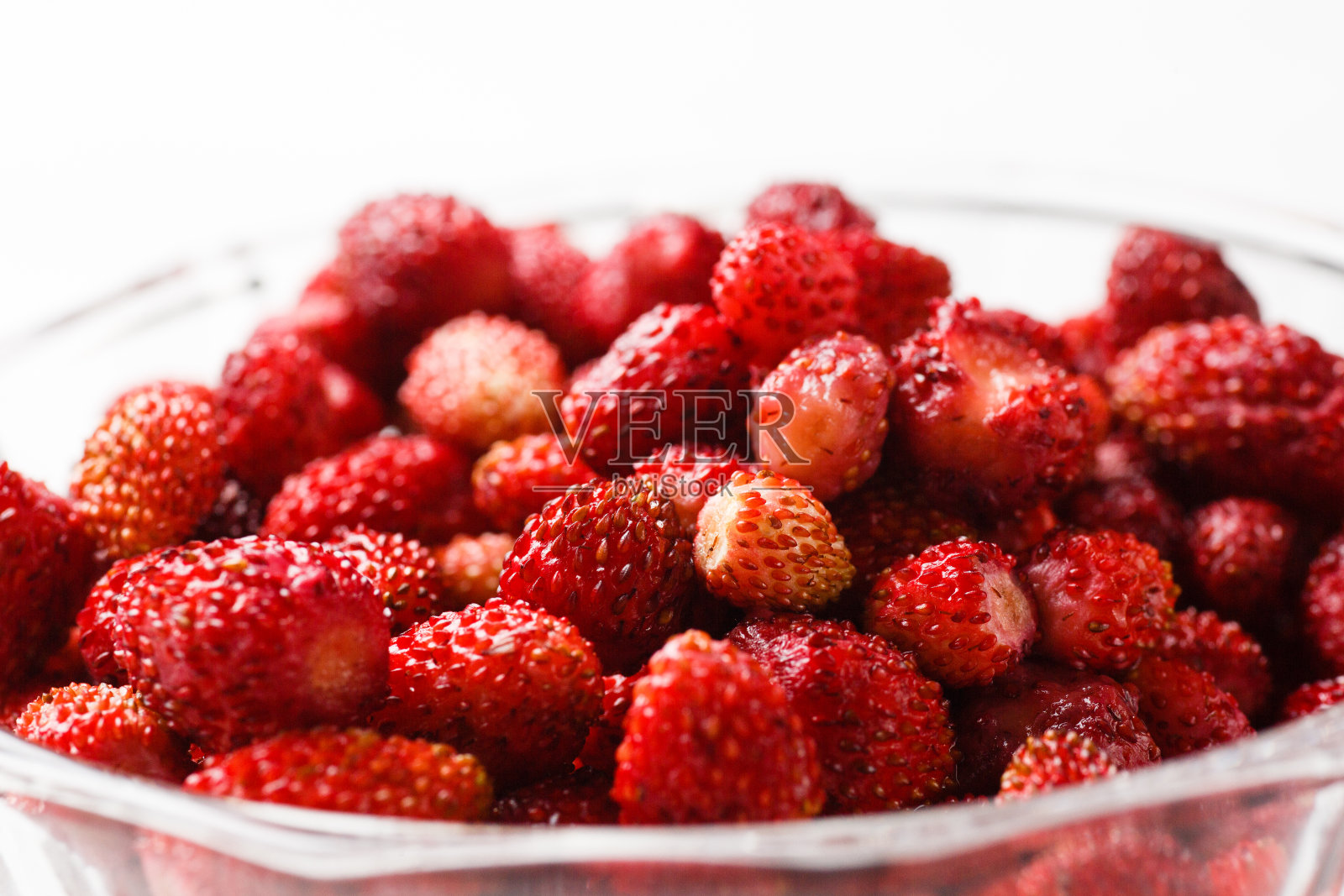白色背景的玻璃盘子里的新鲜草莓。关闭了。照片摄影图片