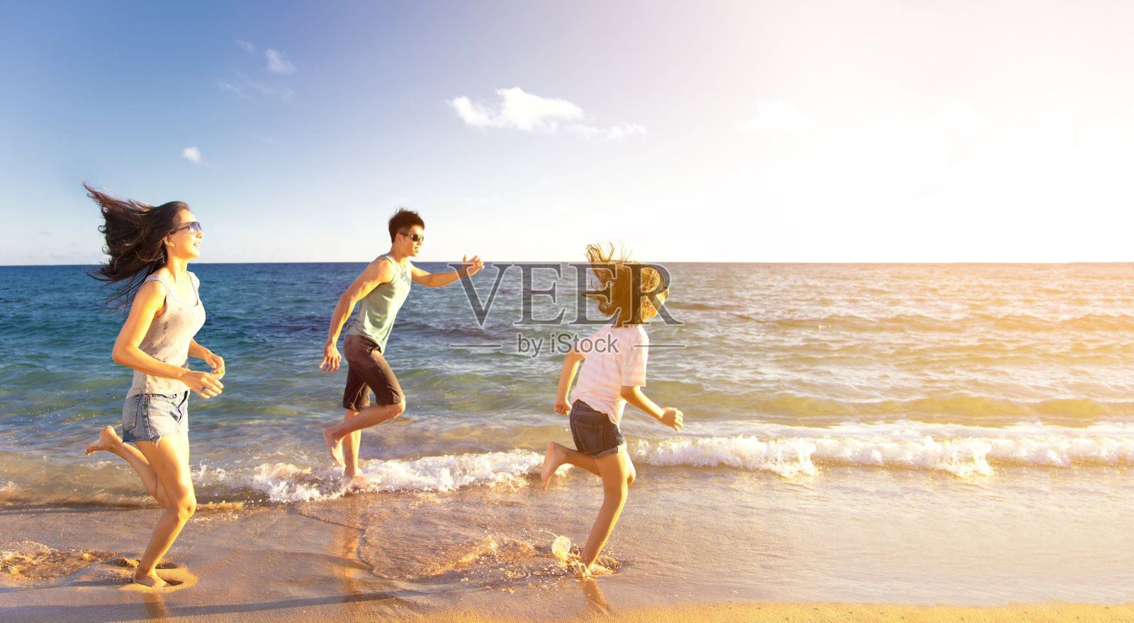 快乐的家庭在沙滩上奔跑照片摄影图片