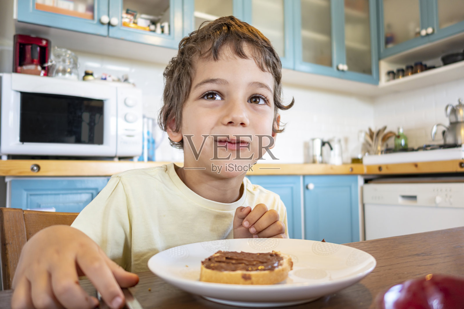 可爱的小男孩在吃早餐照片摄影图片