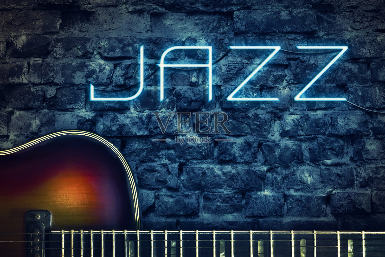 老式吉他和一堵旧砖墙背景上的霓虹爵士乐题词。音乐概念。照片摄影图片