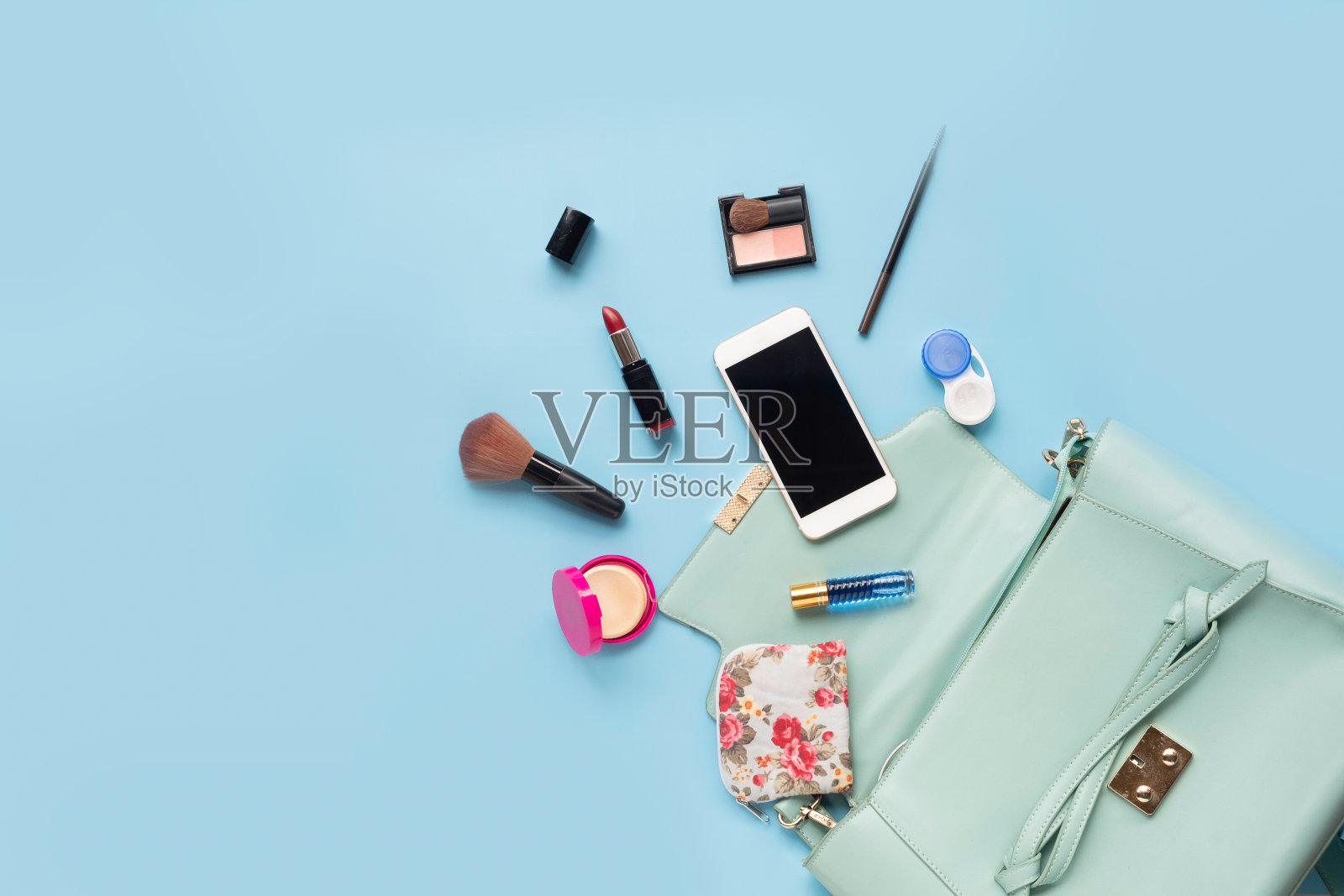 Topview时尚女性配件，手表，眼镜，口红，香水和蓝色包包。所有女孩的必需品，蓝色背景照片摄影图片