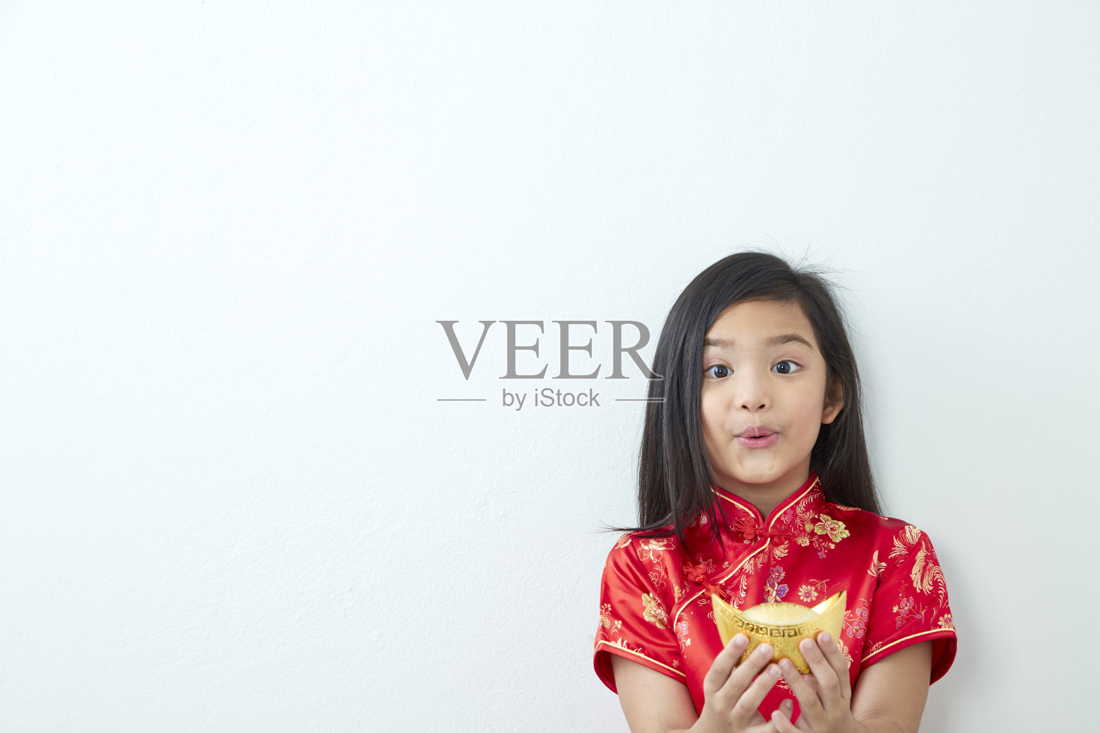 2019年，女孩身着中国传统服饰，手持金元宝站立照片摄影图片