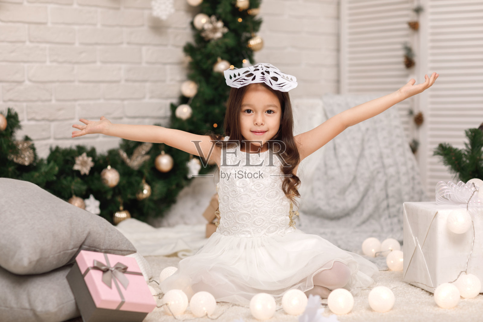 小女孩做纸雪花装饰圣诞树照片摄影图片