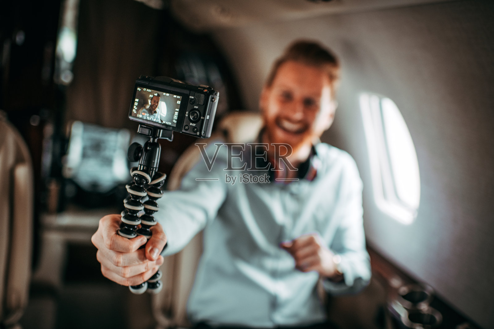 有钱的年轻男子在私人飞机上拍摄视频博客照片摄影图片