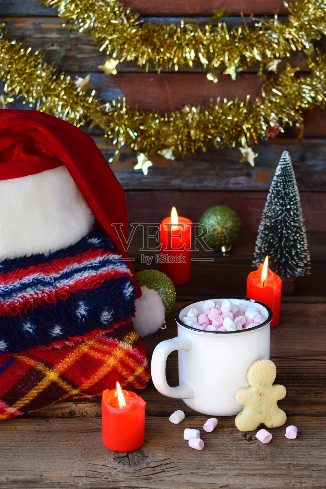 圣诞和新年作文。格子图案，圣诞老人帽，可可杯，棉花糖，姜饼饼干，木制背景上的圣诞树装饰。寒假的概念照片摄影图片