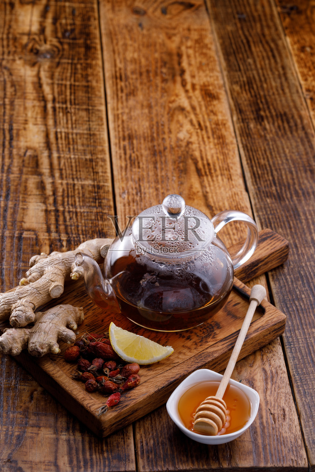玻璃茶壶里的茶，还有玫瑰果、蜂蜜和姜。文本下方的空格。照片摄影图片