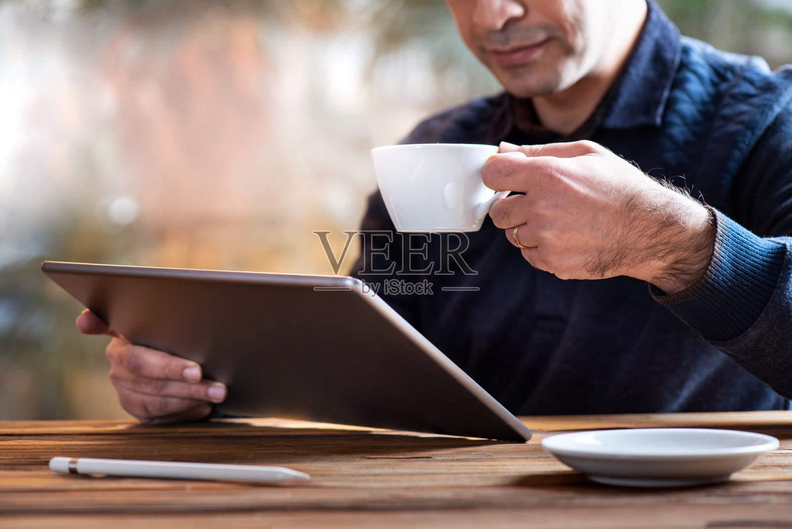 在办公室里喝咖啡的人在平板电脑上工作照片摄影图片