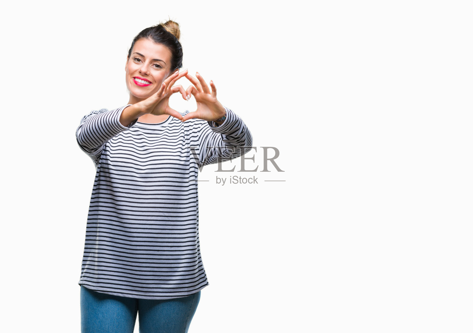 年轻美丽的女人休闲条纹毛衣在孤立的背景微笑在爱显示心形符号和手的形状。浪漫的概念。照片摄影图片
