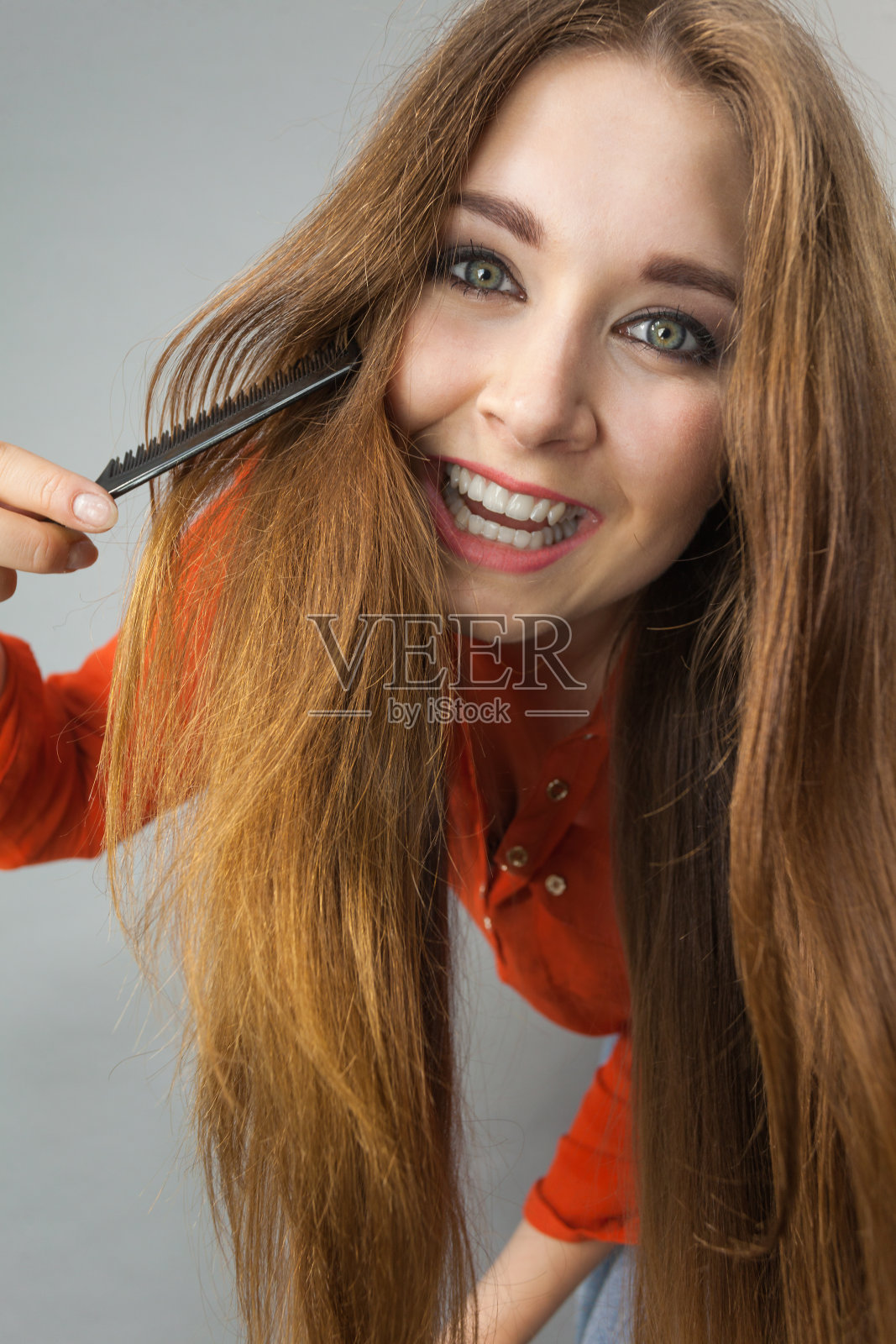 一个女人在梳理她棕色的头发照片摄影图片