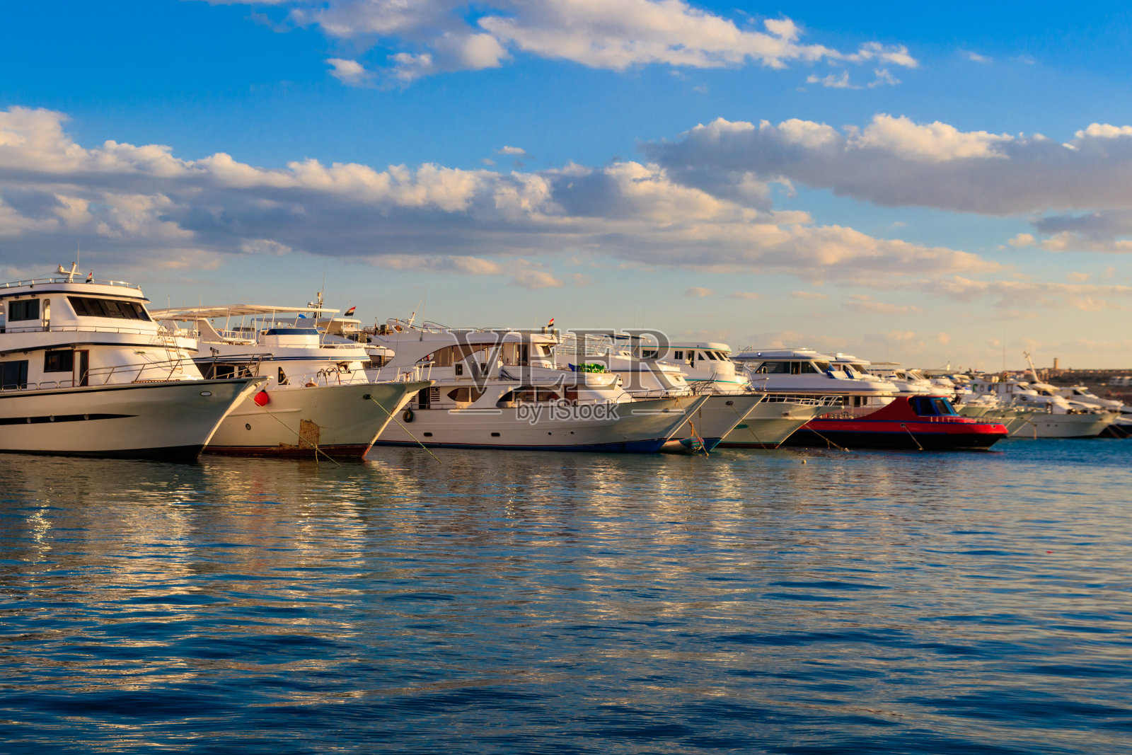 埃及赫尔加达海港的白色游艇。红海上有旅游船的港口照片摄影图片