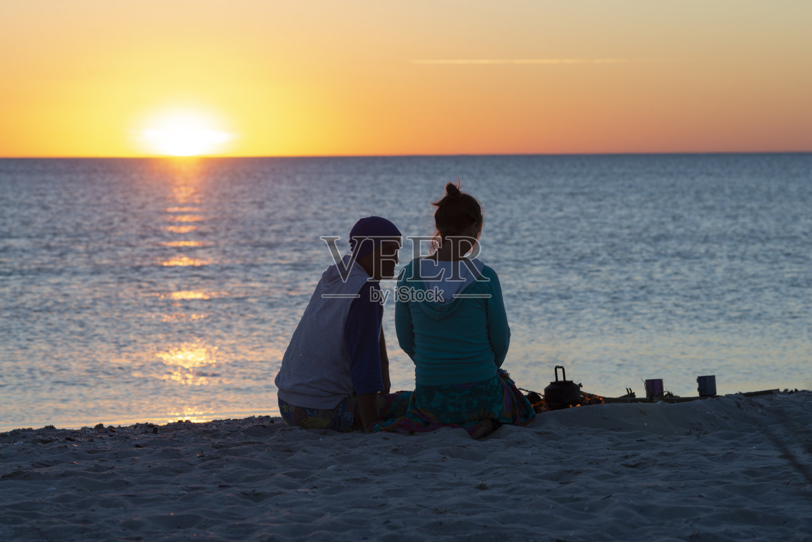 一对浪漫的情侣在海滩上放松，喝着咖啡照片摄影图片