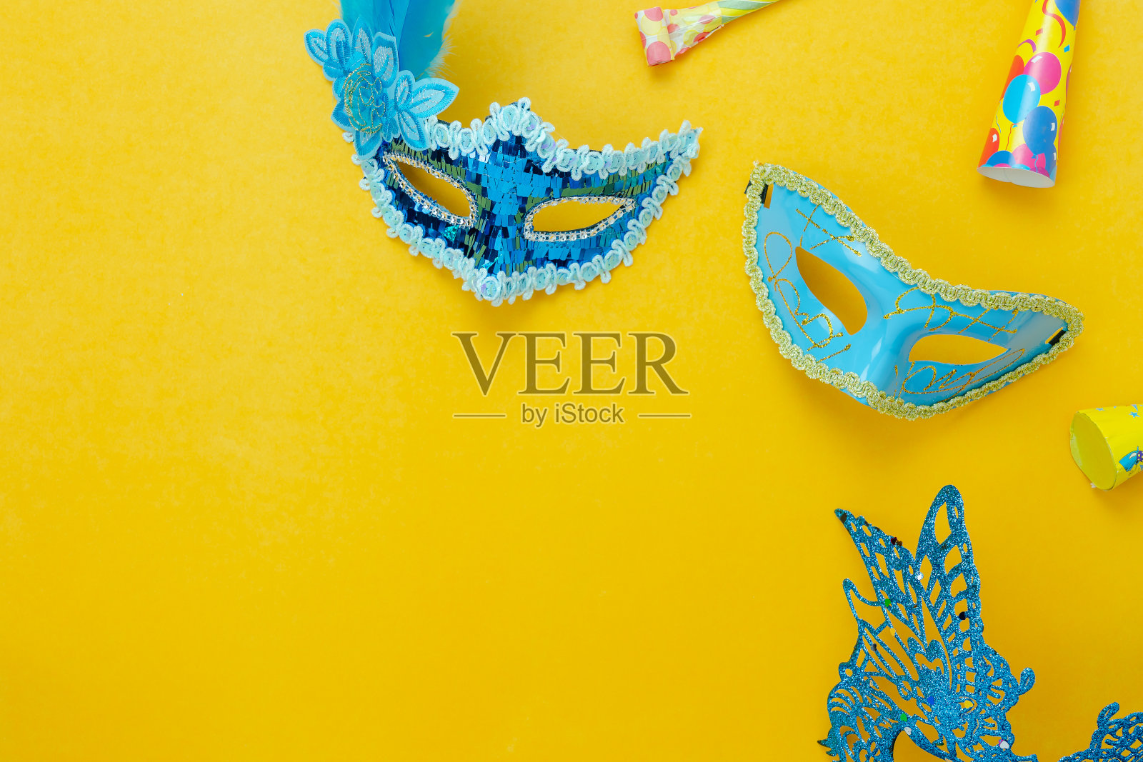 桌面俯瞰航拍图像的美丽多彩的狂欢节季节或照片亭prop Mardi Gras背景。平铺物体蓝色面具与装饰在黄色墙纸。为文本模拟提供空闲空间照片摄影图片