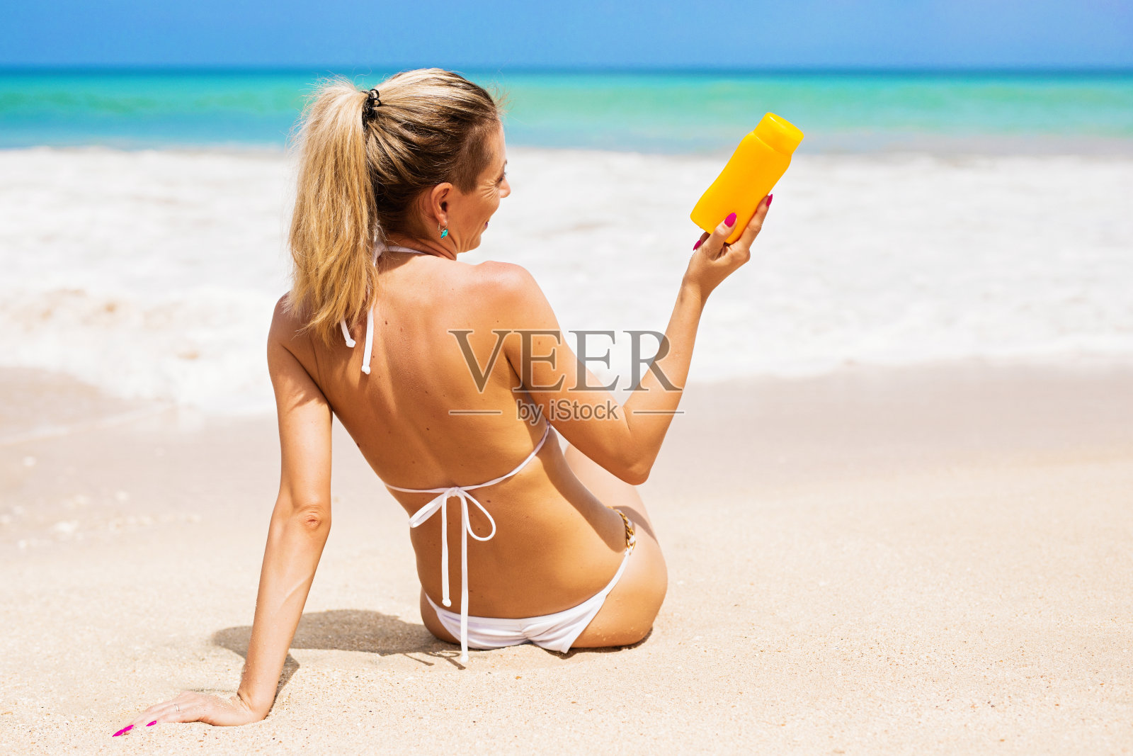 在海滩上晒日光浴的女人照片摄影图片