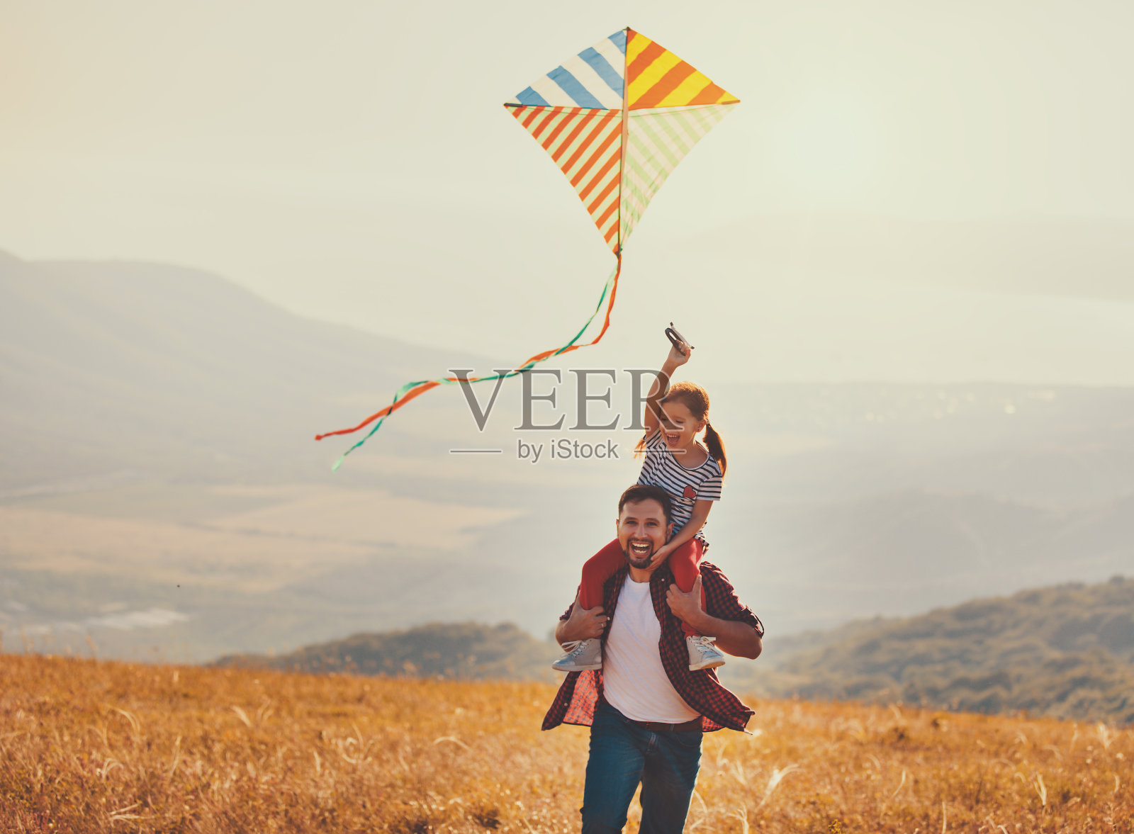 幸福的家庭父亲和孩子女儿在草地上放风筝照片摄影图片