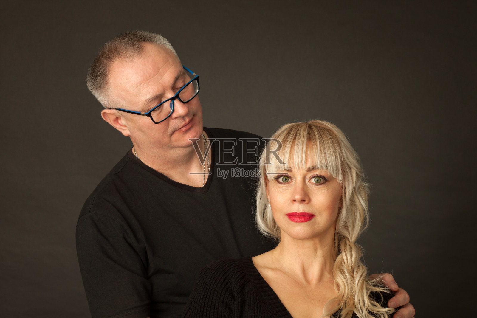 工作室的肖像，一个成熟的异性夫妇在一个黑色的背景照片摄影图片