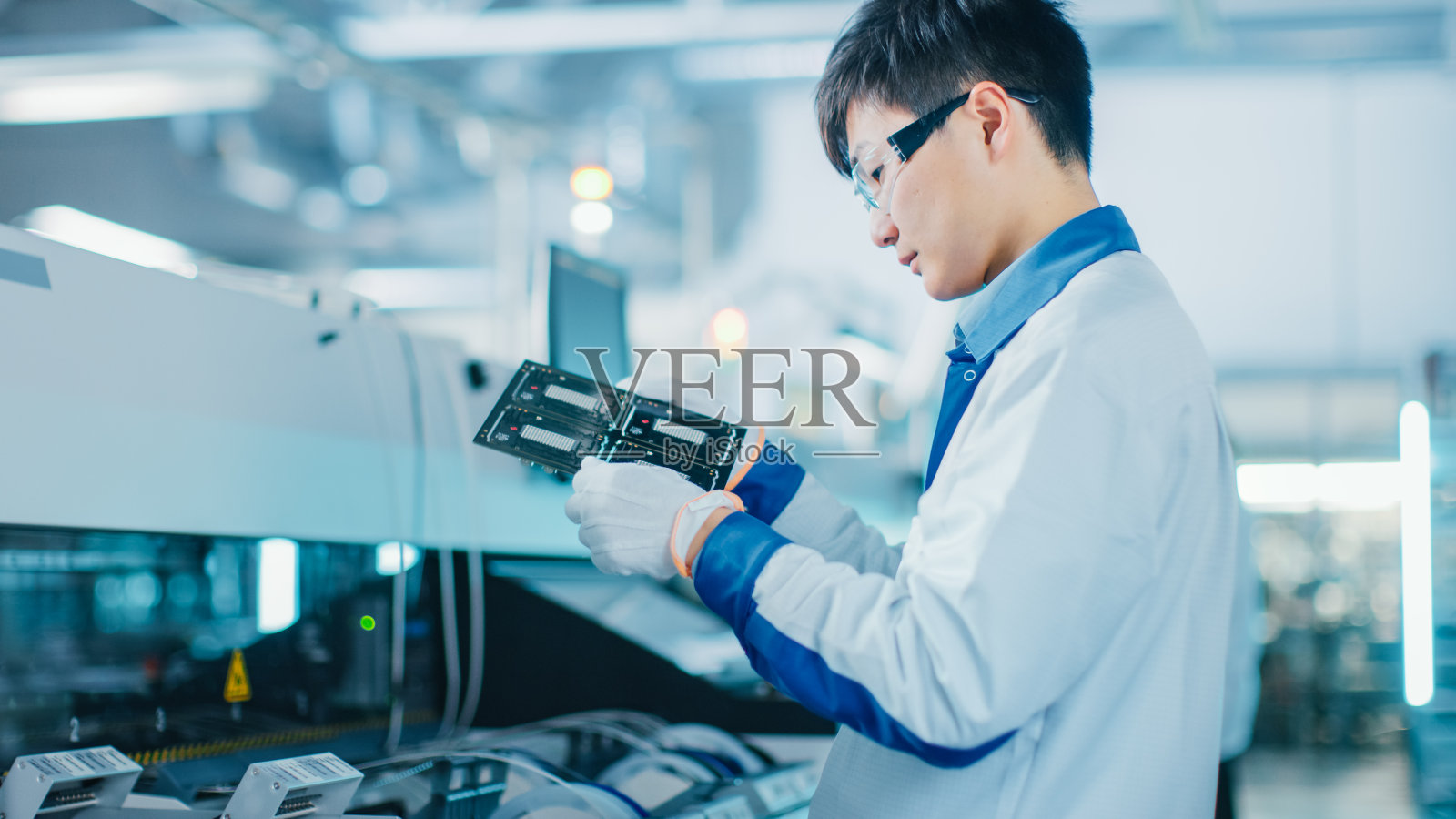 高科技工厂:质量控制工程师检查电子印刷电路板的损坏情况。采用表面贴装取放技术的PCB后台装配线。照片摄影图片