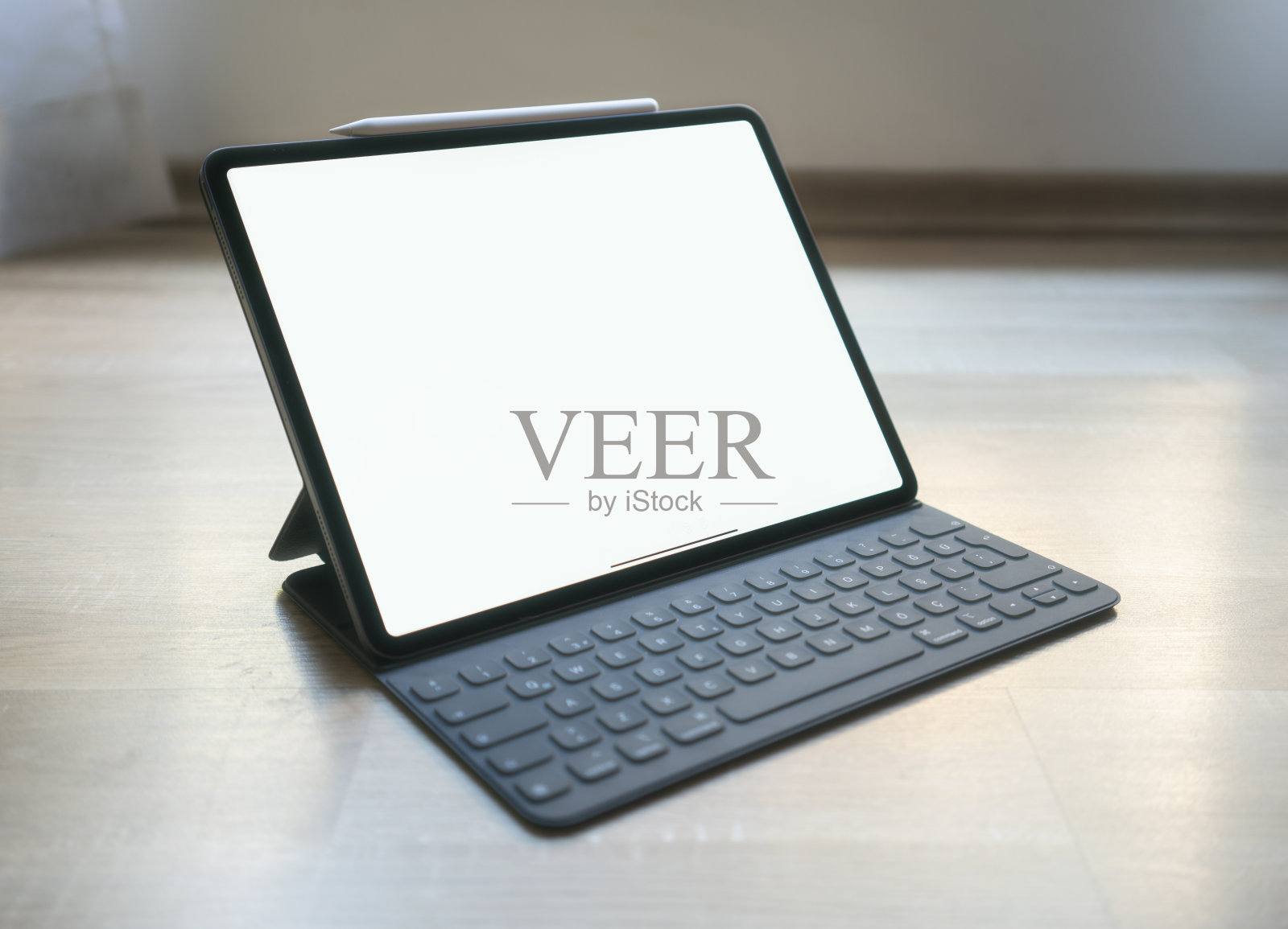 新的专业平板电脑在桌子上与铅笔和键盘覆盖空白屏幕照片摄影图片