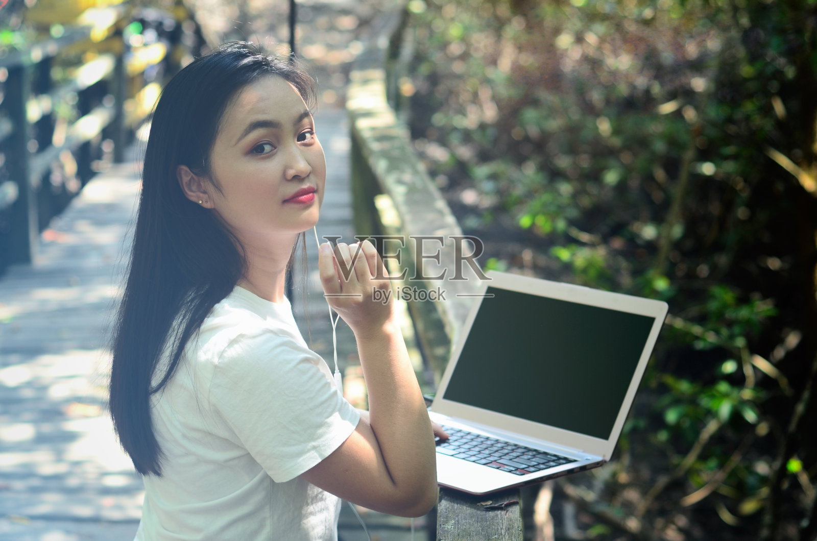 亚洲女性成年人在她的笔记本电脑上。照片摄影图片