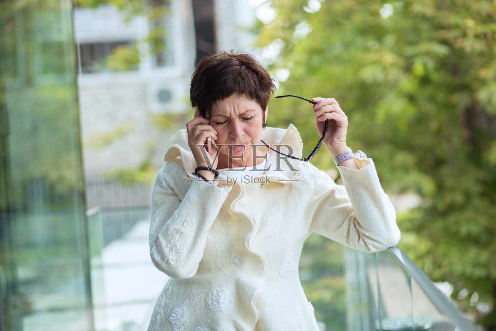 成熟的女商人在阳台上打电话照片摄影图片
