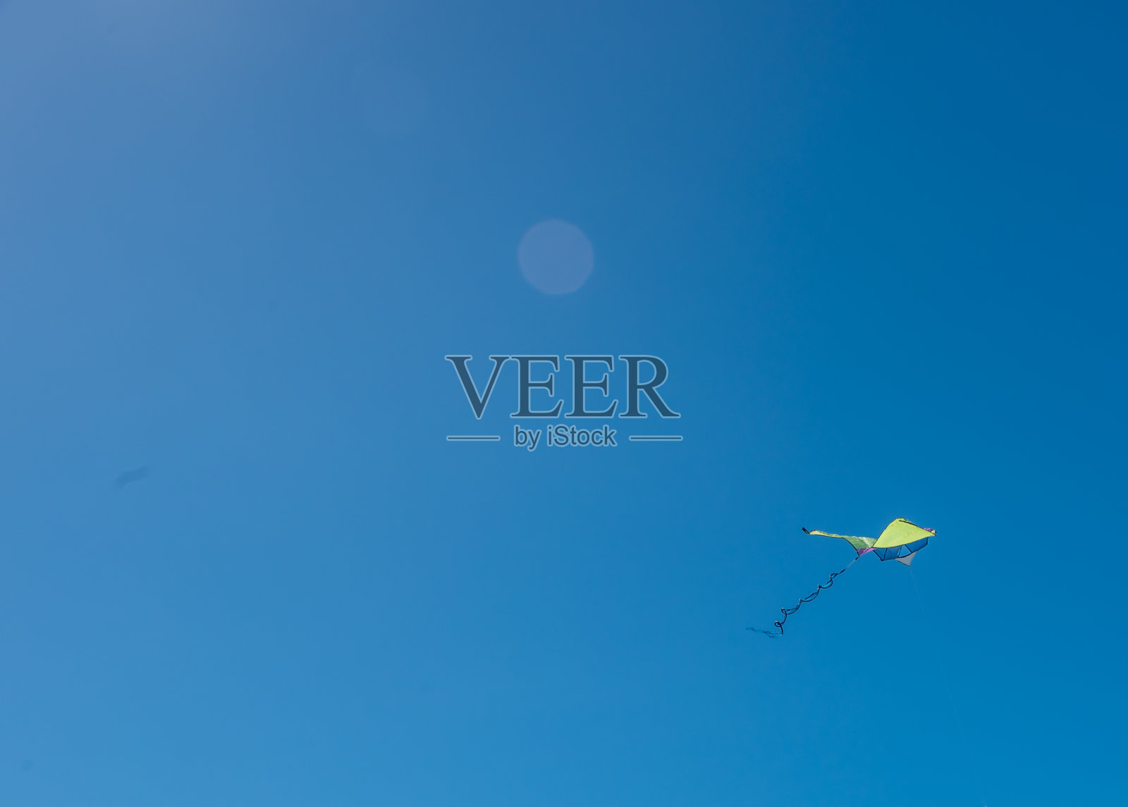 风筝在晴朗的蓝天里飞翔照片摄影图片
