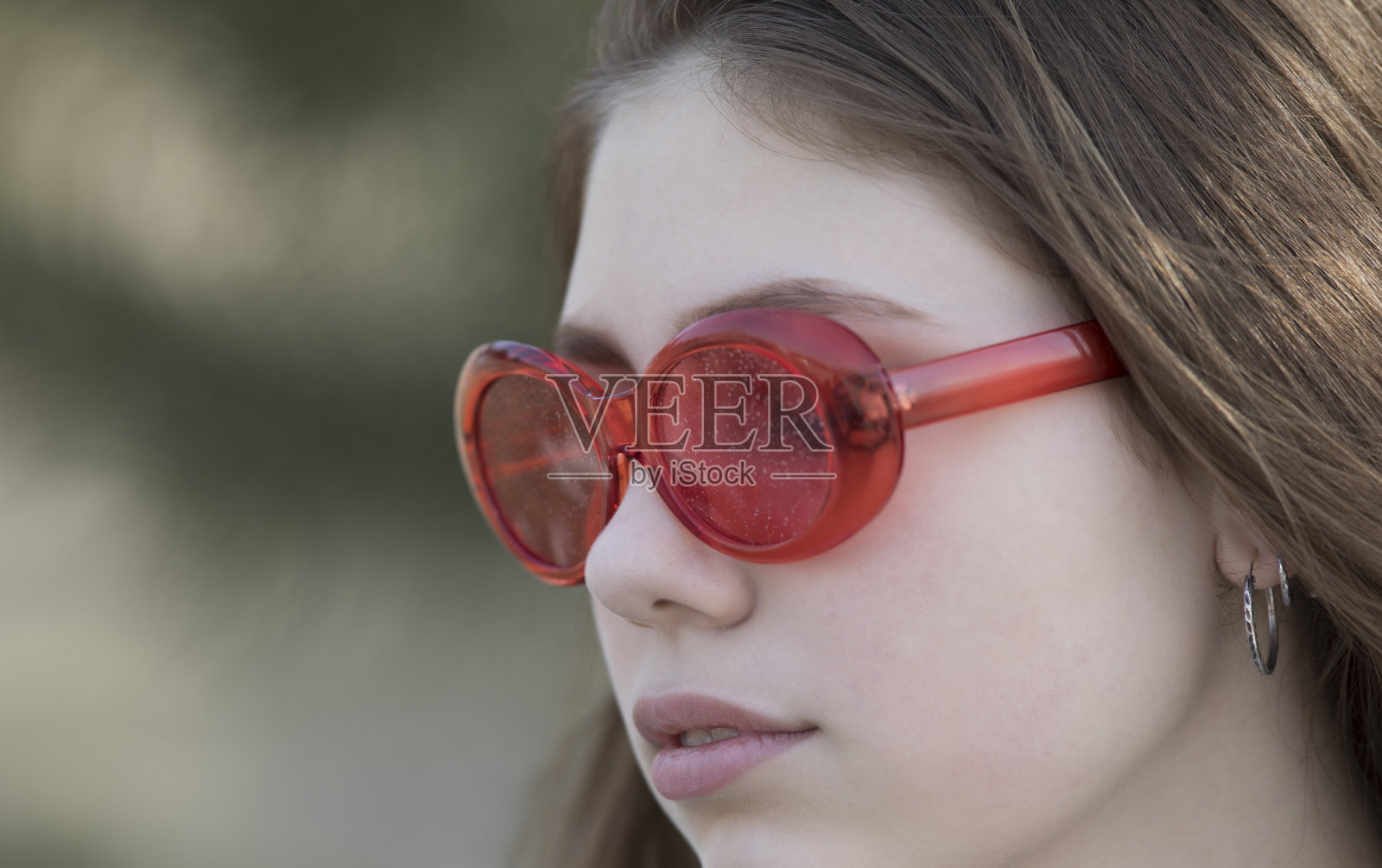 一个戴着红色眼镜的年轻女孩的眼睛的特写照片摄影图片