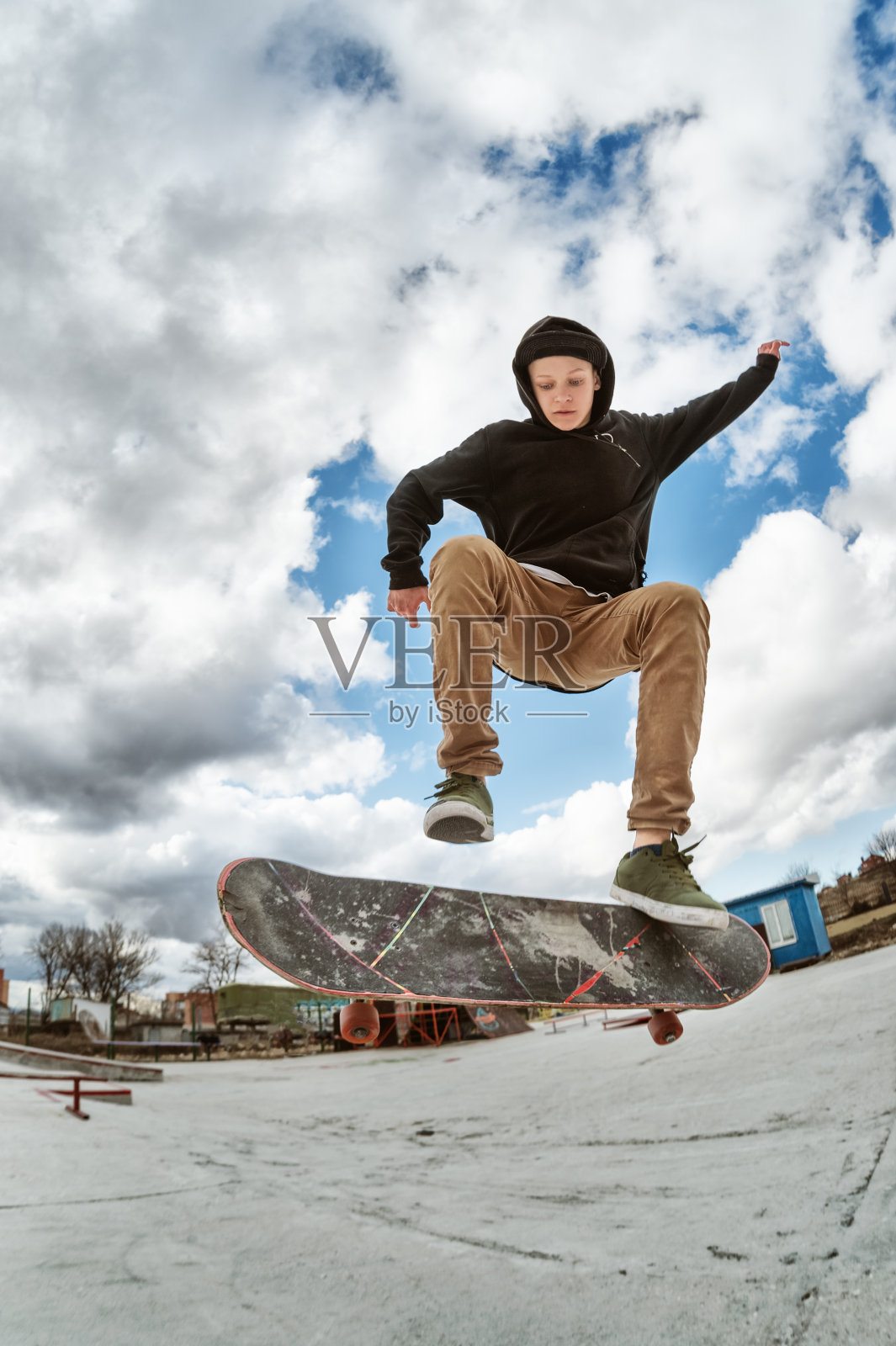 一个年轻的滑板使Wallie在一个滑板公园，跳上一个滑板到空中与政变照片摄影图片