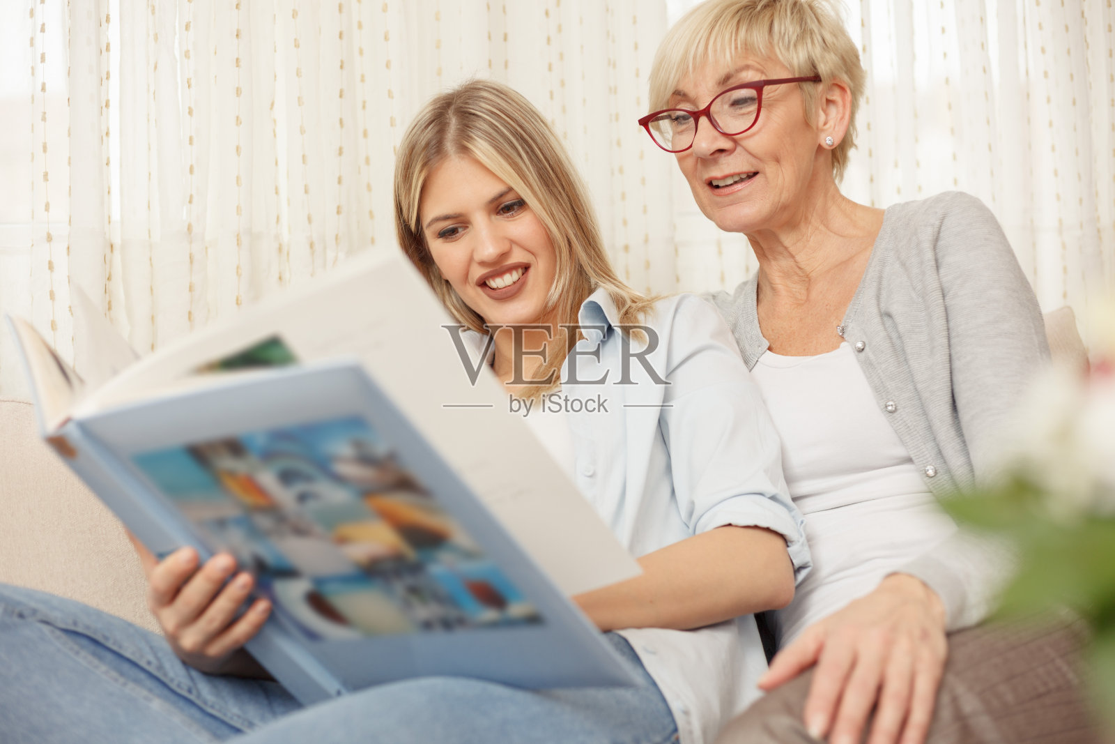 母女俩在翻看旧家庭相册照片摄影图片