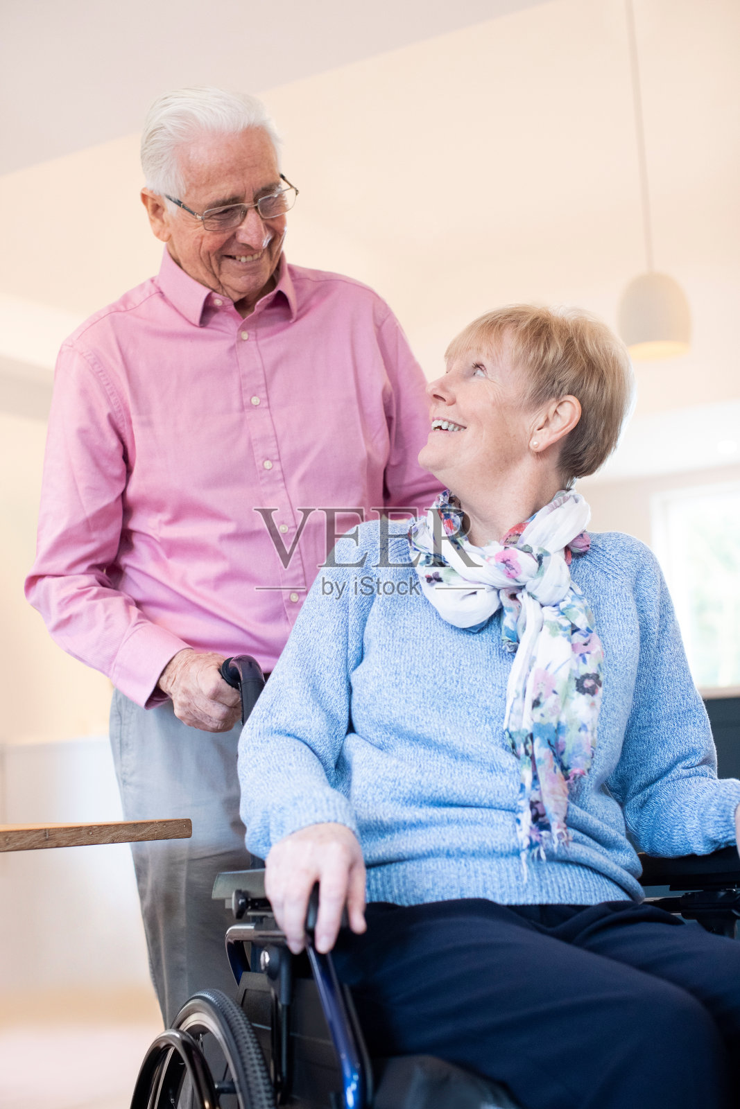 在家里用轮椅推着妻子的老人照片摄影图片