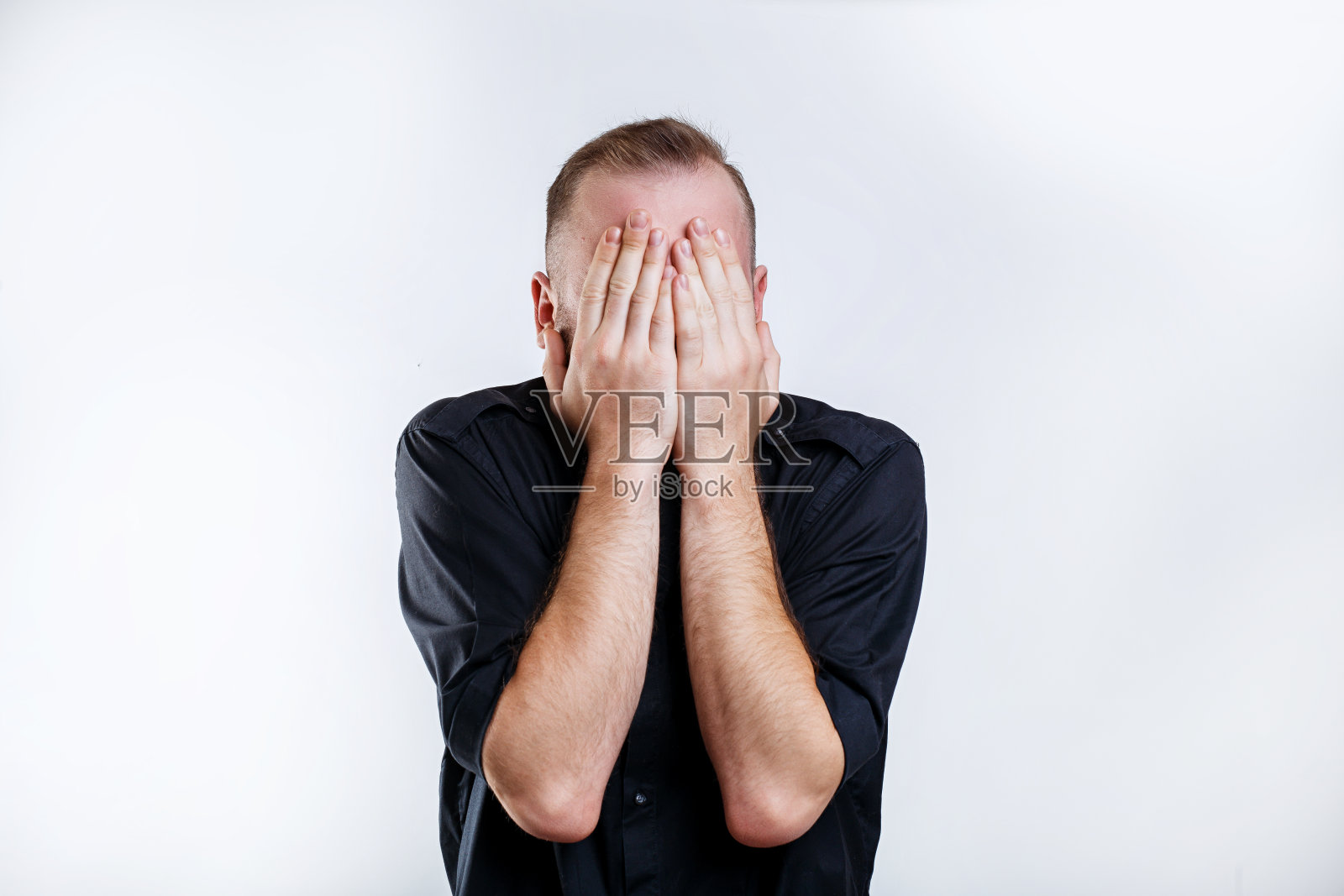 一个穿着黑衬衫的男人用手闭上了眼睛照片摄影图片