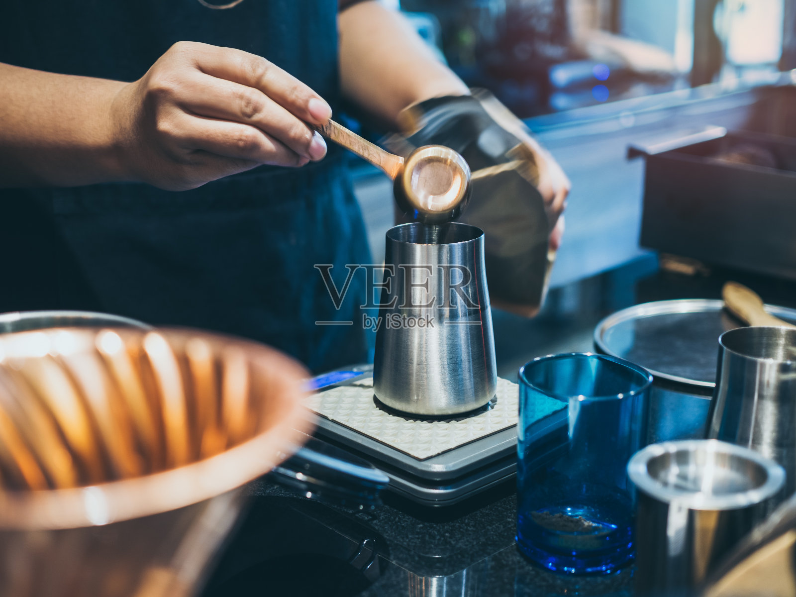 咖啡师将咖啡粉放入不锈钢咖啡研磨机照片摄影图片
