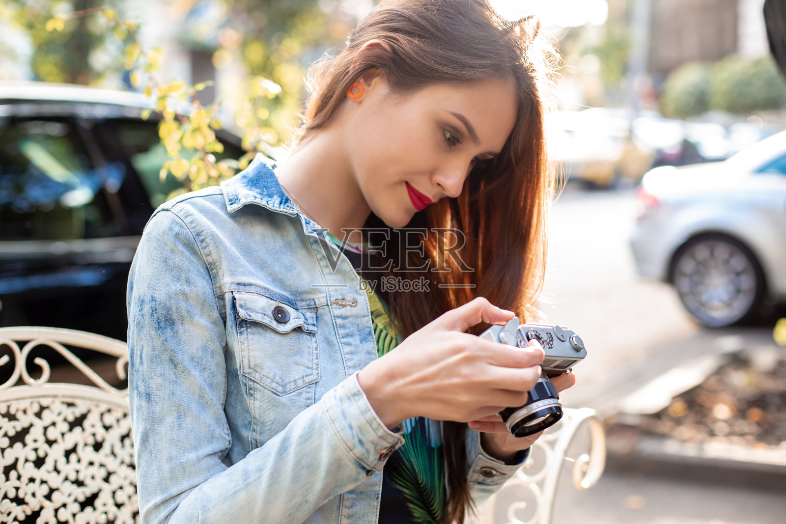 快乐的潮妹在城市街道上用复古相机拍照照片摄影图片