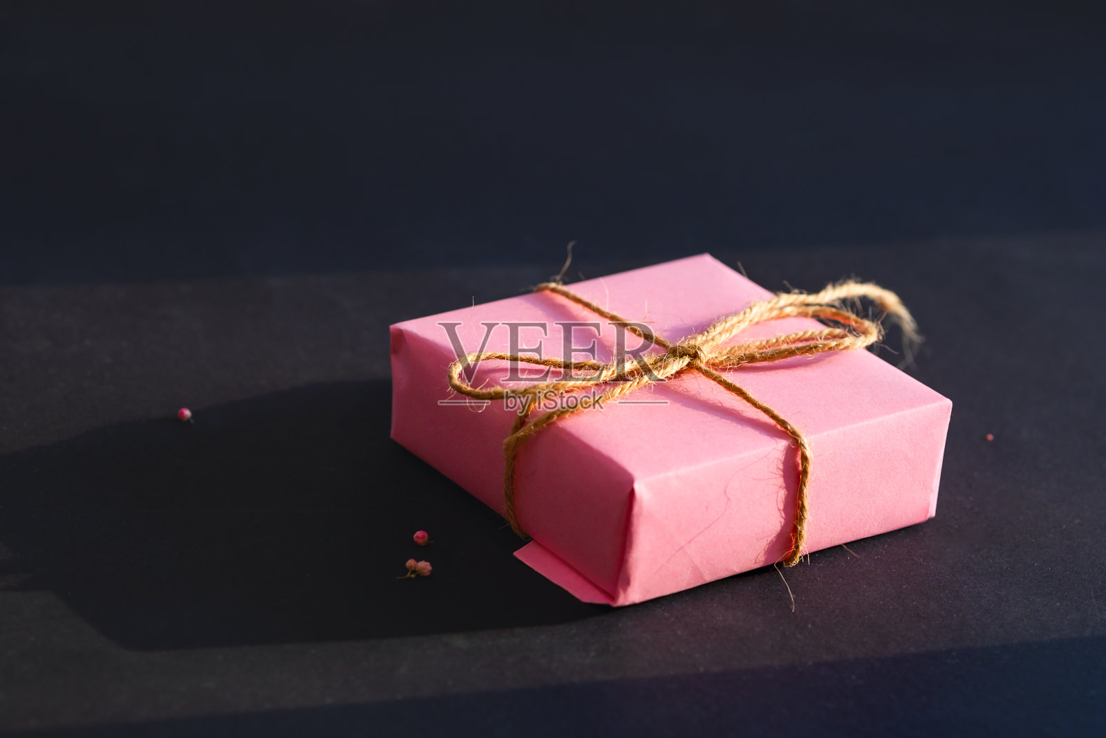 黑色背景上的粉色礼品盒。最小的概念。照片摄影图片
