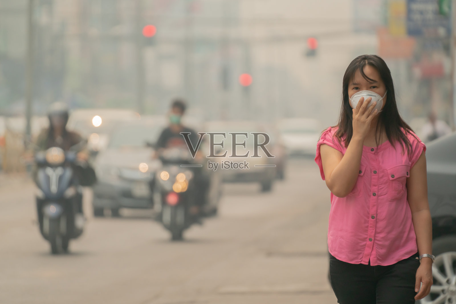 年轻女子戴着防护面具在城市街道，泰国清迈照片摄影图片