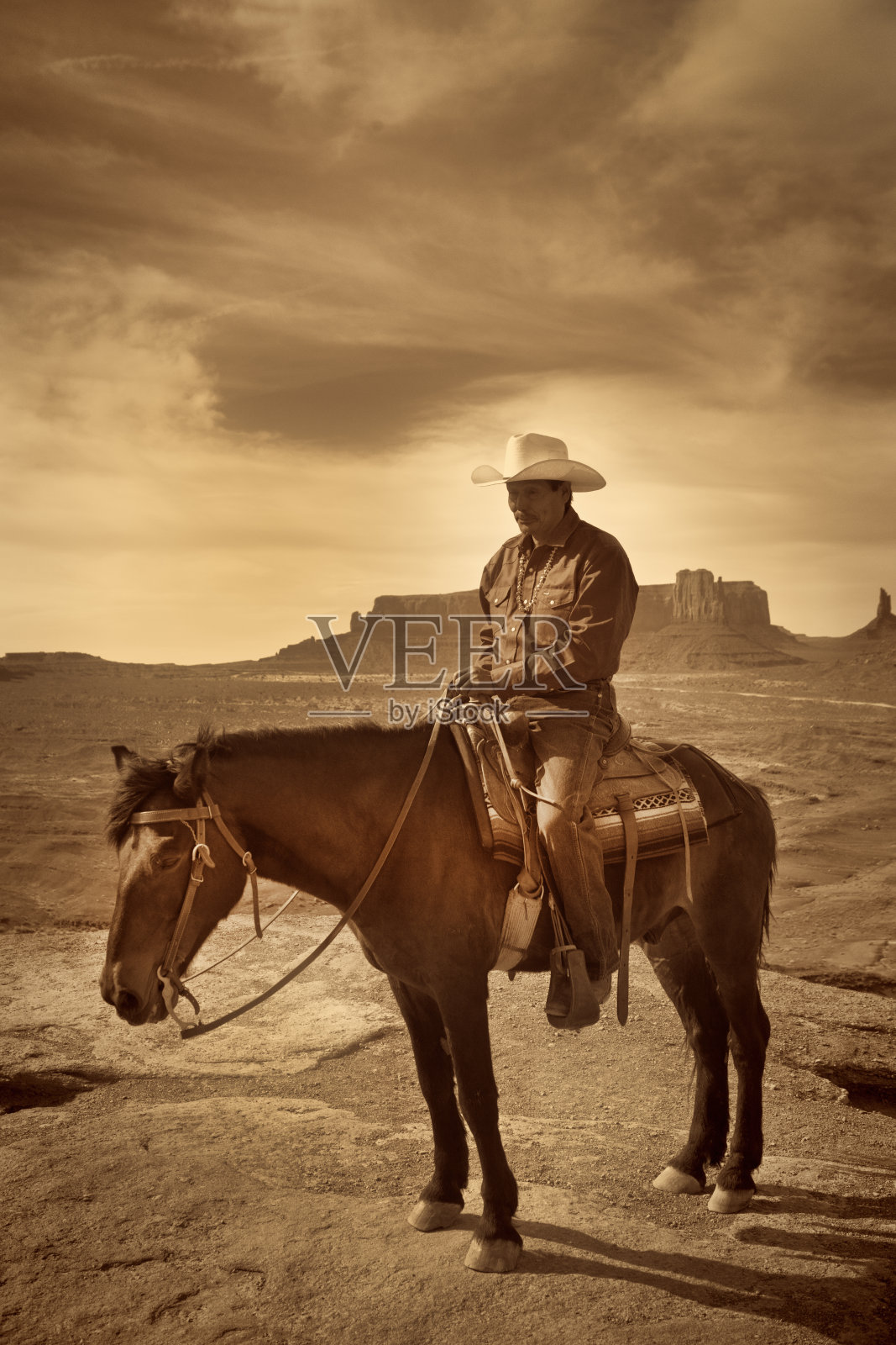 在纪念碑谷部落公园骑马的美国土著西部牛仔照片摄影图片