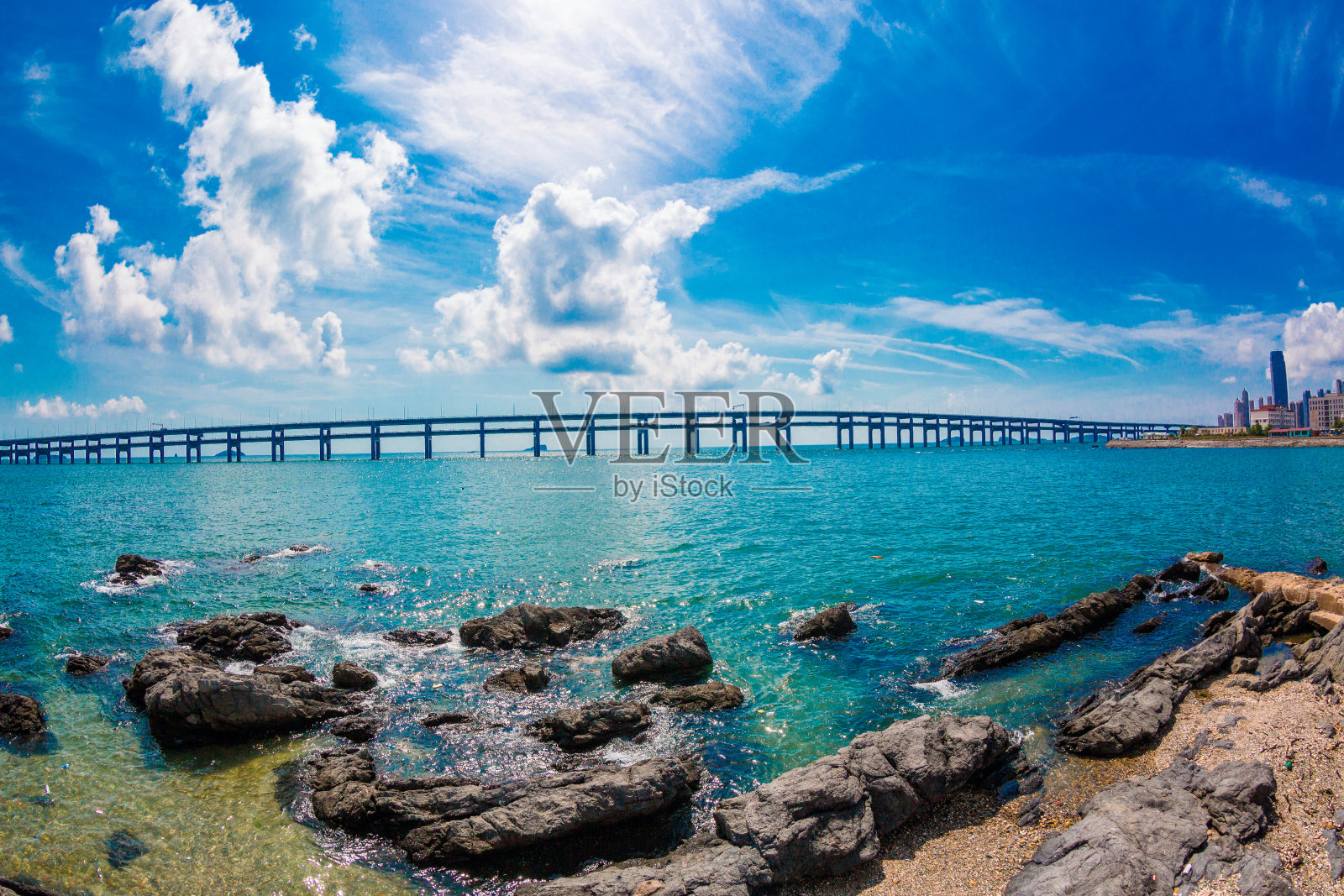 蓝天黑礁，城市，大海，跨海大桥照片摄影图片